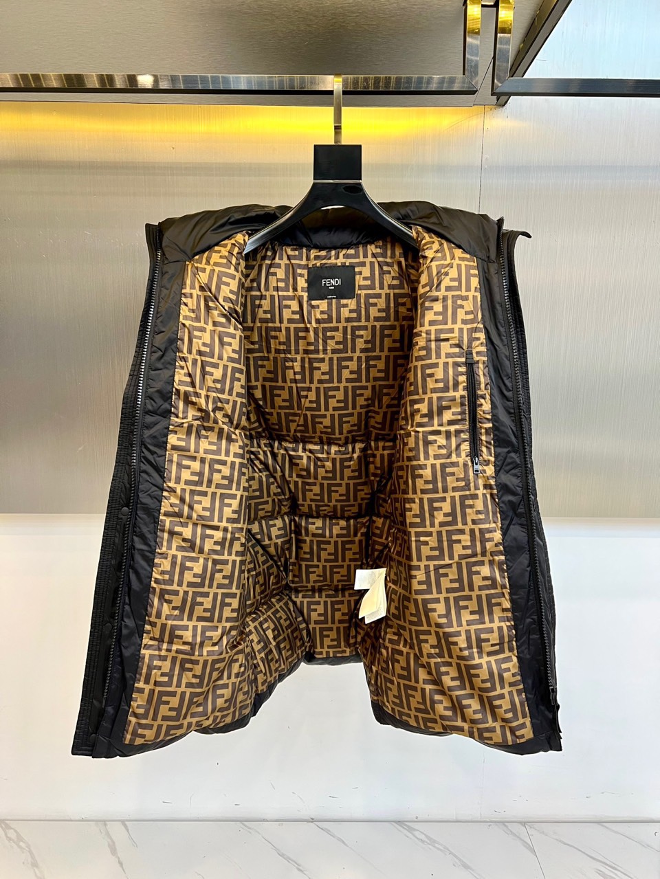 Fend芬迪（鹅绒）、2025秋冬新品羽绒服以经典黑色演绎奢华冬日美学。这款长款羽绒服采用连帽设计，帽檐