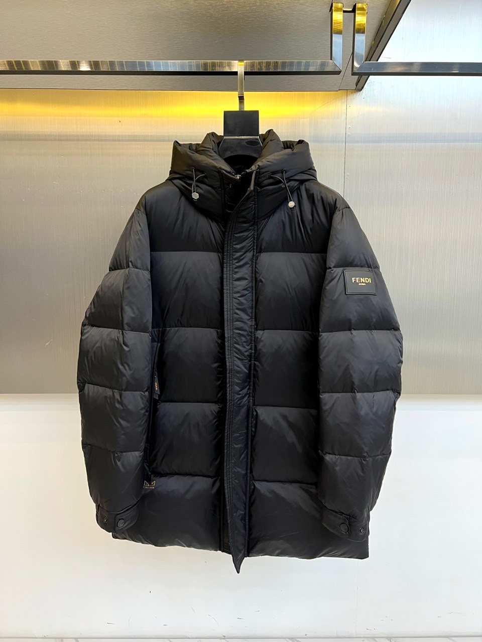 Fend芬迪（鹅绒）、2025秋冬新品羽绒服以经典黑色演绎奢华冬日美学。这款长款羽绒服采用连帽设计，帽檐
