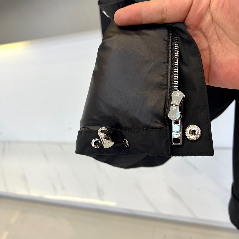 Prada/普拉、男士织物面料连帽羽绒夹克外套。这款现代运动风羽绒夹克采用织物面料和Oversize宽大