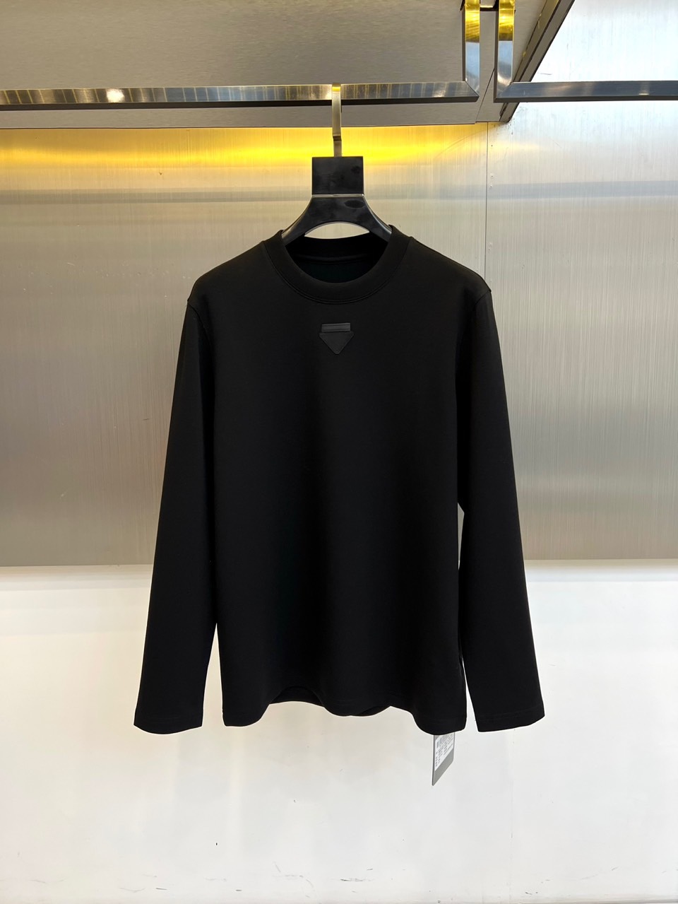 Prad普拉、普拉达2025秋冬新品莫代尔磨毛长袖上衣，以极简圆领设计诠释当代优雅风范。胸前点缀标志性倒