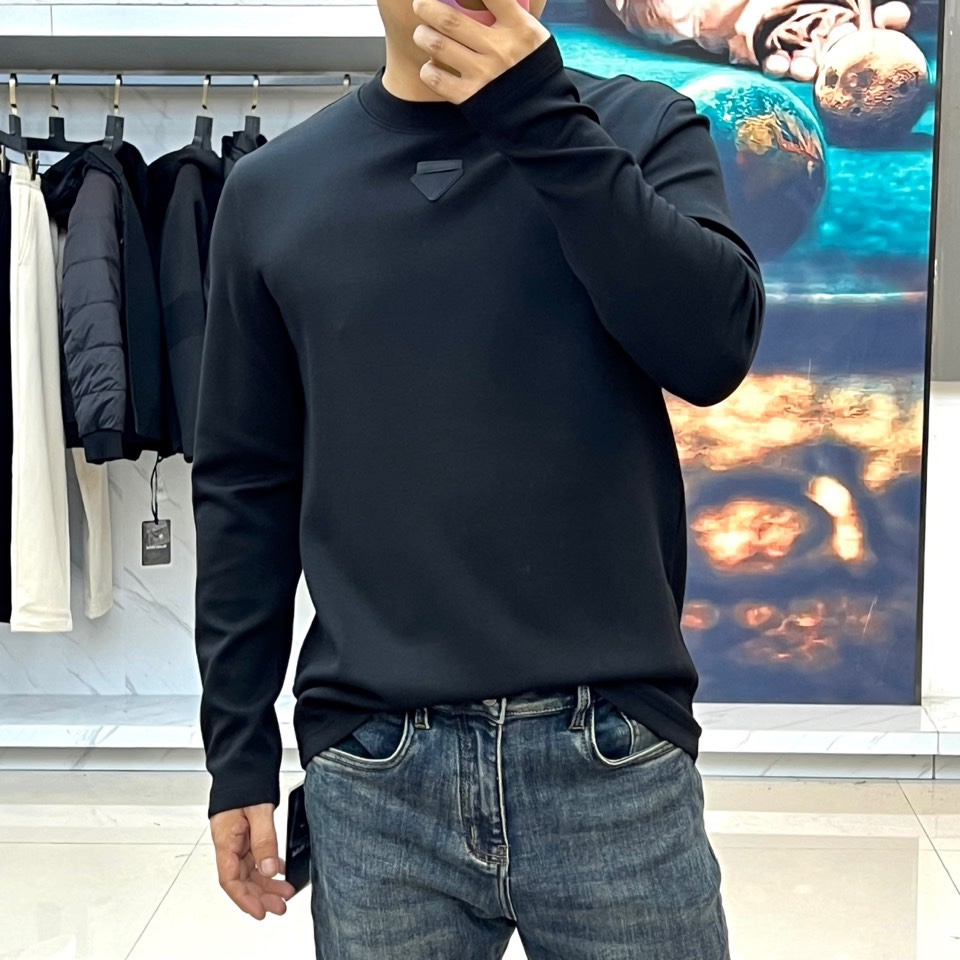 Prad普拉、普拉达2025秋冬新品莫代尔磨毛长袖上衣，以极简圆领设计诠释当代优雅风范。胸前点缀标志性倒