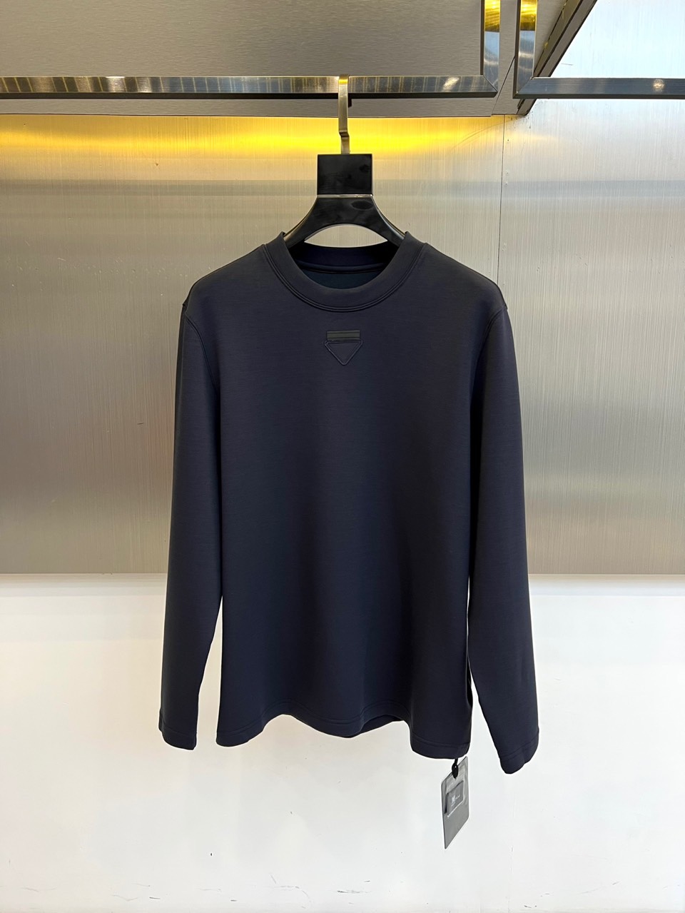 Prad普拉、普拉达2025秋冬新品莫代尔磨毛长袖上衣，以极简圆领设计诠释当代优雅风范。胸前点缀标志性倒