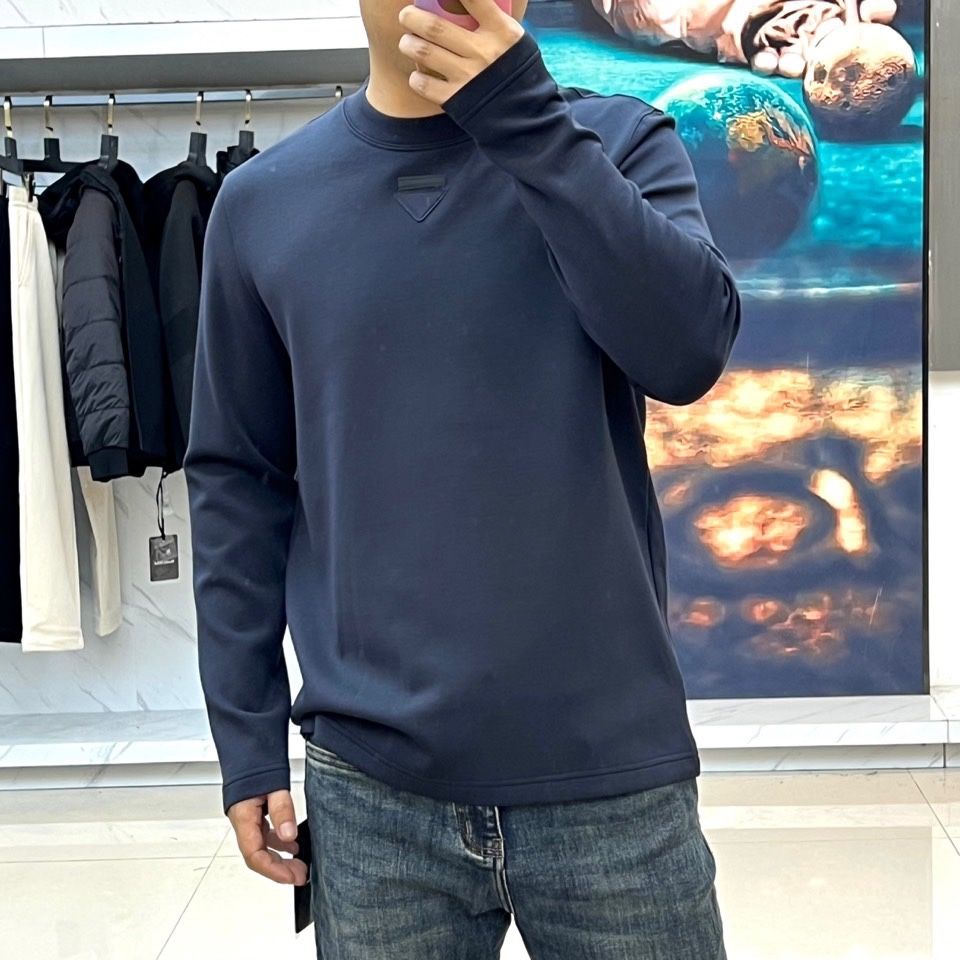 Prad普拉、普拉达2025秋冬新品莫代尔磨毛长袖上衣，以极简圆领设计诠释当代优雅风范。胸前点缀标志性倒