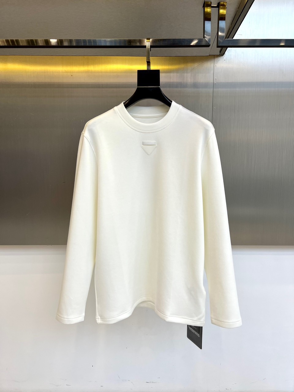 Prad普拉、普拉达2025秋冬新品莫代尔磨毛长袖上衣，以极简圆领设计诠释当代优雅风范。胸前点缀标志性倒