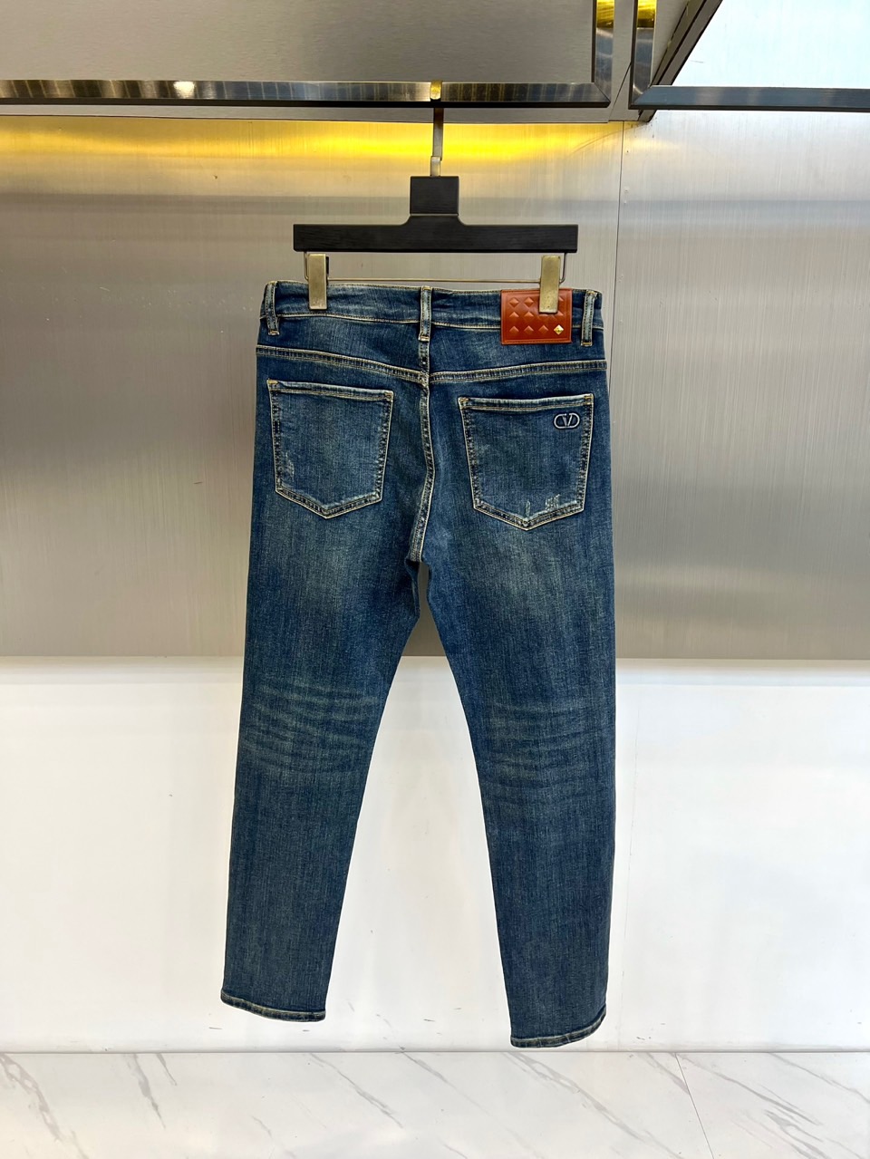 VT华伦天奴、2025秋冬新品深蓝色牛仔裤，以经典丹宁重塑现代奢华美学。后袋上方装饰标志性棕色菱格纹皮革