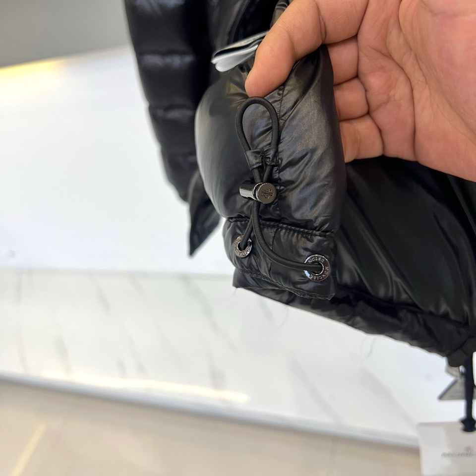 Mon蒙口、2025秋冬新品羽绒服，连帽设计搭配顺滑拉链开合，左臂饰有品牌标志性黑白条纹织带与浮雕徽章，