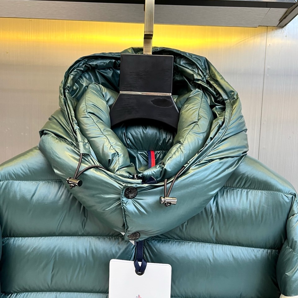 Mon蒙口、2025秋冬新品羽绒服，连帽设计搭配顺滑拉链开合，左臂饰有品牌标志性黑白条纹织带与浮雕徽章，
