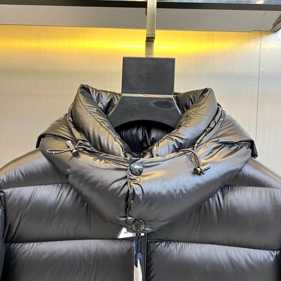 Mon蒙口、2025秋冬新品羽绒服，连帽设计搭配顺滑拉链开合，左臂饰有品牌标志性黑白条纹织带与浮雕徽章，