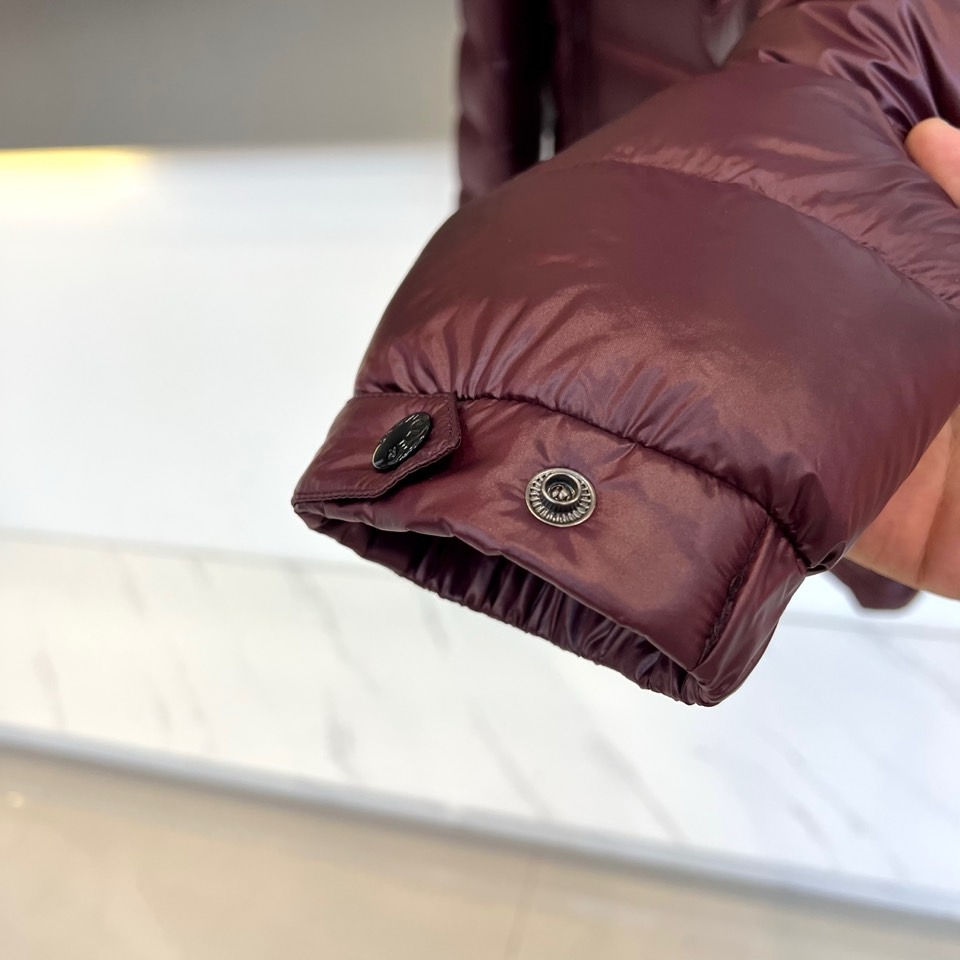Mon蒙口、2025秋冬新品羽绒服，连帽设计搭配顺滑拉链开合，左臂饰有品牌标志性黑白条纹织带与浮雕徽章，
