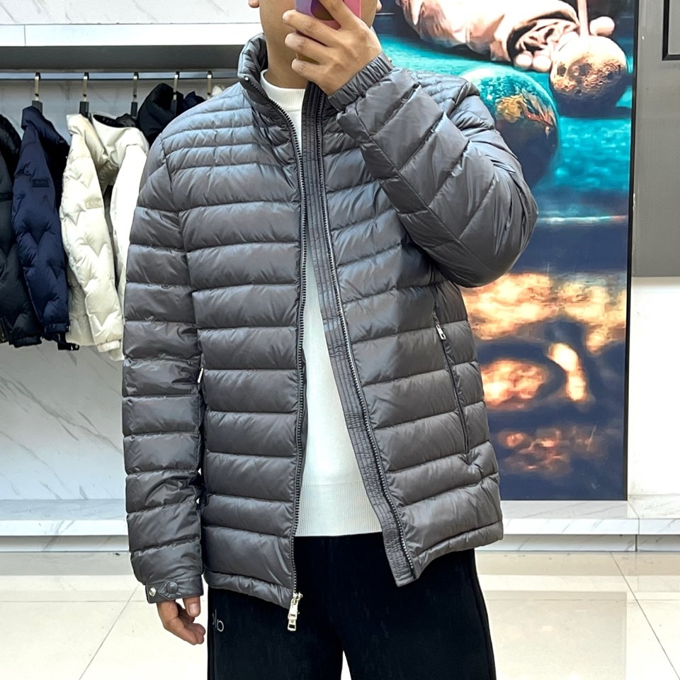 Mon蒙口（纯鹅绒）、2025秋冬新品羽绒服以深灰色调演绎现代极简美学，立领设计搭配银色拉链开合，衣身通