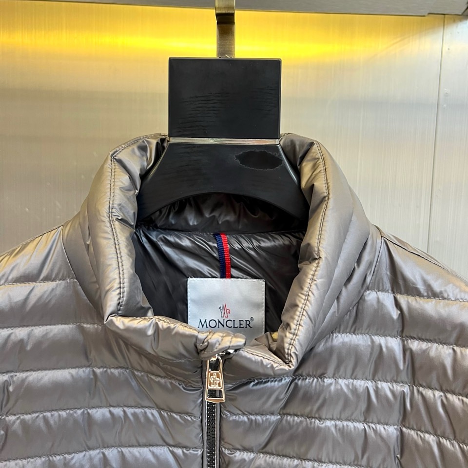 Mon蒙口（纯鹅绒）、2025秋冬新品羽绒服以深灰色调演绎现代极简美学，立领设计搭配银色拉链开合，衣身通