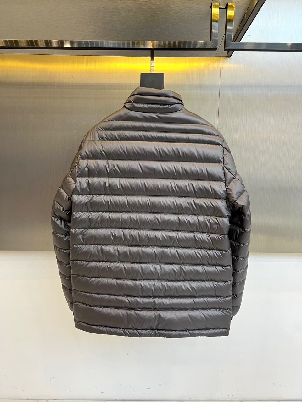 Mon蒙口（纯鹅绒）、2025秋冬新品羽绒服以深灰色调演绎现代极简美学，立领设计搭配银色拉链开合，衣身通