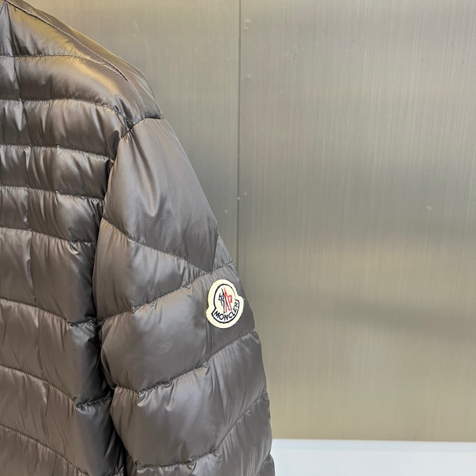 Mon蒙口（纯鹅绒）、2025秋冬新品羽绒服以深灰色调演绎现代极简美学，立领设计搭配银色拉链开合，衣身通