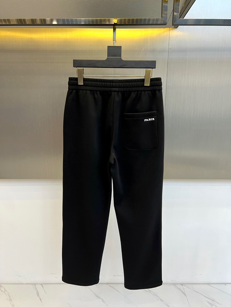 Prad普拉、2025秋冬新品运动长裤，以标志性设计语言诠释现代休闲美学。款式采用弹性抽绳腰头设计，两侧