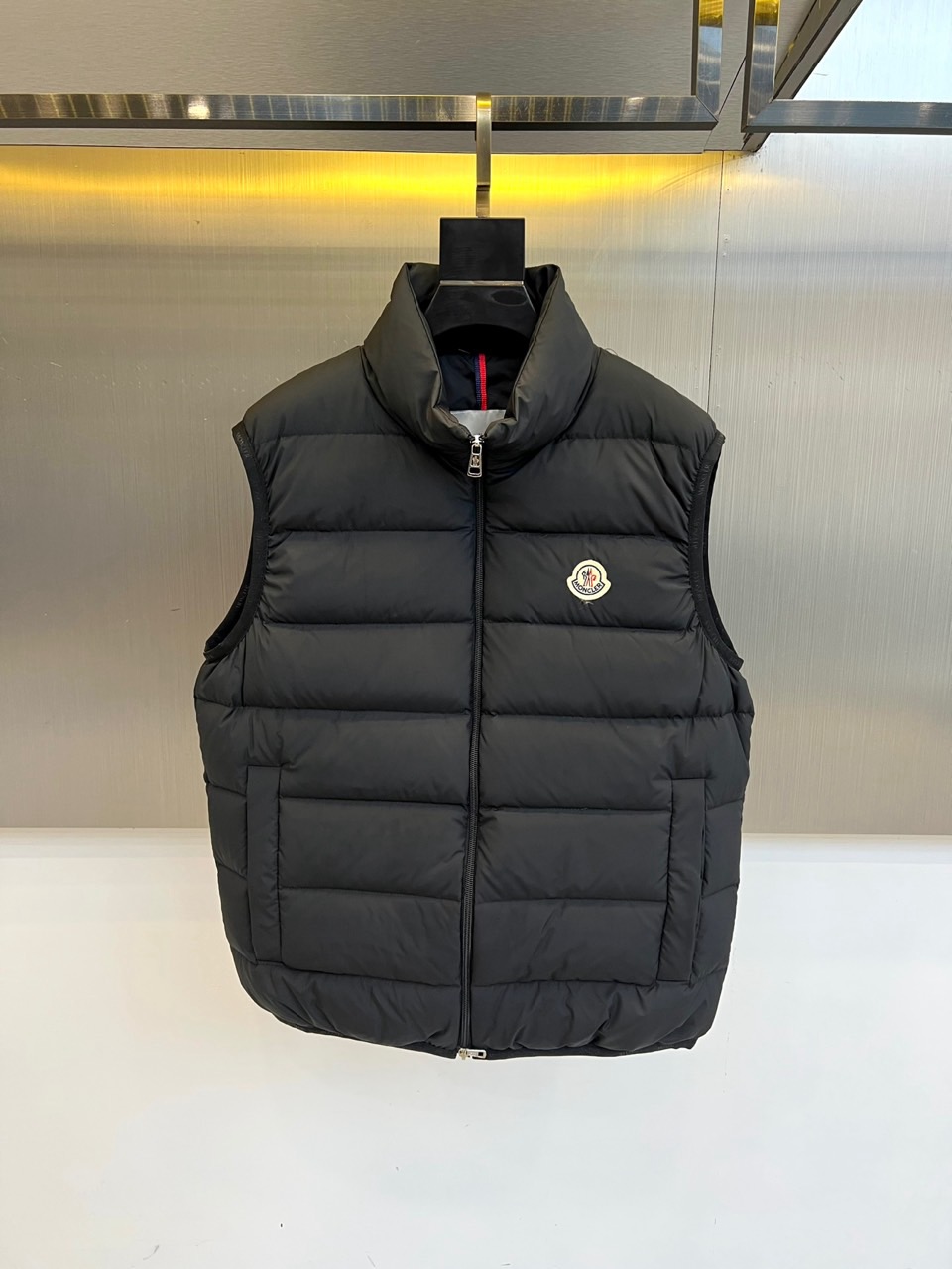 NO:621900,Mon, the new autumn and winter down vest, adopts a stand-up collar design and a smooth zipper opening and closing system. The left chest is embellished with the iconic colorful round badge. It forms regular geometric divisions through precise horizontal quilting technology. It is filled with 90% high-quality white goose down to ensure 2  It is lightweight and warm with 7 grams of down content, and the fabric is made of nylon to enhance windproof performance. Its design combines practical functions with urban fashion. The sleeveless cut allows full freedom of arm movement, and can be flexibly matched with knitted sweaters or sweatshirts to create layered outfits. From business  From commuting to outdoor leisure, this vest can be adapted to a variety of scenes with a low-key texture. It not only maintains the thermal insulation properties of down items, but also breaks through the traditional heaviness through a neat silhouette. The craftsmanship standards made in the Republic of Moldova and the brand logo in the details confirm the commitment to quality.  Persistent pursuit, becoming a smart choice for autumn and winter wardrobe that is both practical and fashionable. 48-56 (model weighs 173,143 pounds, upper body size 50),,Moncler,hoodie,sweatshirts,down  jacket,alexander wang19860909Mon蒙口、秋冬新款羽绒马甲,款马甲采用立领设计与顺滑拉链开合系统,左胸点缀标志性彩色圆形徽章,通过精准的横向绗缝工艺形成规整的几何分割.填充90优质白鹅绒确保27克充绒量的轻盈保暖性,面料采用锦纶材质增强防风性能.其设计将实用功能与都市时尚相融合,无袖剪裁为手臂活动留出充分自由度,可灵活搭配针织衫或卫衣打造层次穿搭.从商务通勤到户外休闲,这款马甲能以低调质感适配多种场景,既保持羽绒单品保暖特性,又通过利落版型突破传统厚重感.摩尔多瓦共和国制造的工艺标准与细节处的品牌标识,印证对品质的执着追求,成为秋冬衣橱中兼具实穿性与时尚感的智慧之选.48-56（模特173,143斤上身50码）,,Moncler,hoodie,sweatshirts,down jacket,alexander wang,Men's clothing
