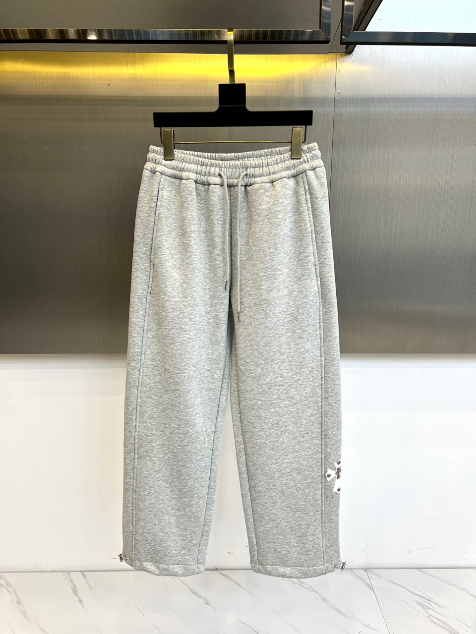 NO:626402,Ch Croix Heart, new autumn and winter fleece trousers, with an elasticated waistband and adjustable drawstring design to achieve a personalized fit experience. The straight-cut trouser legs create smooth lines, and the trouser legs are embellished with iconic zipper details, which not only retains the brand's iconic design language but also adds practical functions. The classic brand logo under the right trouser leg highlights the identity in a low-key way.  The surface of the fabric shows a delicate plaid texture, and the interior is made of dense and soft white velvet material, forming a dual internal and external thermal insulation system. The straight-cut design ensures freedom of movement while maintaining a neat silhouette. The velvet interior provides warmth and care, and the external material has both stiffness and comfort, perfectly balancing temperature and style.  This fleece trousers continues Crow Heart's iconic dark rock style. The light gray tone has both matching potential and daily practicality. The zipper design on the trouser legs can be flexibly adjusted to suit different dressing needs. Whether it is paired with motorcycle boots for a street look or sports shoes for a casual style, it can be displayed  A unique trend attitude. By combining luxurious texture with practical design, Chrome Heart creates this iconic item suitable for daily wear in autumn and winter, providing fashion enthusiasts with an outfit choice that takes into account both warmth needs and fashion expression. S-XXL (please state your height and weight when placing an order),,chrome  hearts,boots,sneakers,alexander wang19860909Ch克罗心、秋冬新品加绒裤,松紧腰头搭配可调节抽绳设计,实现个性化贴合体验.直筒剪裁的裤腿营造流畅线条,裤脚处点缀标志性拉链细节,既保留品牌标志性设计语言又增添实用功能.右侧裤腿下方的经典品牌标识以低调方式彰显身份. 面料表面呈现细腻格纹肌理,内部则采用密实柔软的白色绒毛材质,形成内外双重保暖系统.直筒版型设计确保活动自由度,同时保持利落轮廓.加绒内里提供温暖呵护,外部材质兼具挺括感与舒适度,完美平衡温度与风度. 这款加绒裤延续了克罗心标志性的暗黑摇滚风格,浅灰色调兼具搭配潜力与日常实穿性.裤脚拉链设计可灵活调节开合状态,适应不同穿搭需求.无论是搭配机车靴打造街头造型,还是搭配运动鞋呈现休闲风格,都能展现独具个性的潮流态度.克罗心通过将奢华质感与实用设计相结合,创造出这款适合秋冬日常穿着的标志性单品,为潮流爱好者提供兼顾保暖需求与时尚表达的穿搭选择.S-XXL（下单请报身高体重）,,chrome hearts,boots,sneakers,alexander wang,Men's clothing