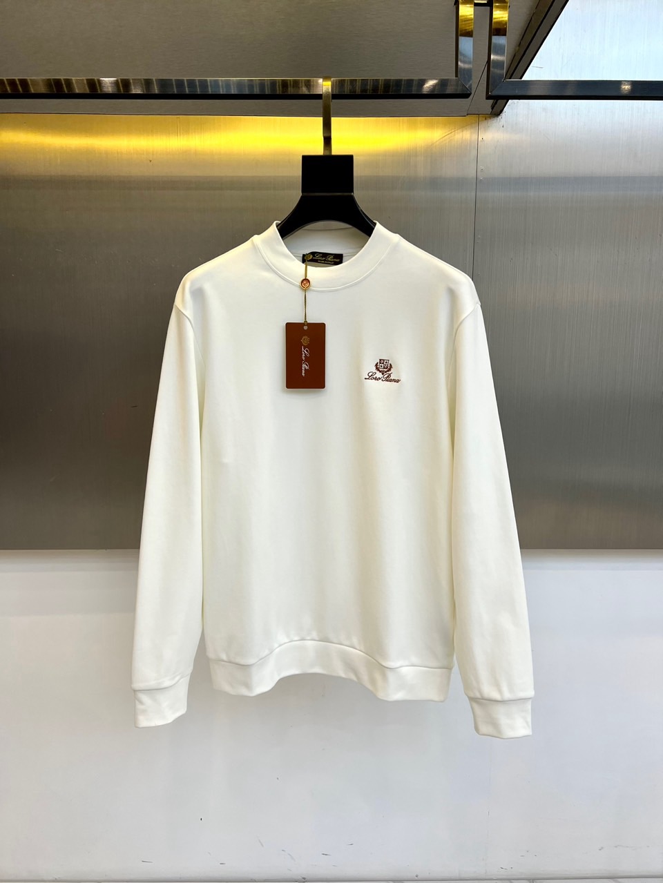 NO:648441,Loro Piana's new round-neck sweatshirt for autumn and winter. The classic round neck uses double-layer fabric hemming technology to ensure that the neckline will last for a long time and will not be deformed. The left chest is decorated with the brand's iconic embroidered badge, using silk threads of the same color to outline a delicate three-dimensional pattern, which only shows a low-key luster under certain light. The cuffs and hem are edged with high-density ribs, and the inside is brushed to improve wearing comfort.  The body of the garment is made of the brand's unique vicuña and cotton blended fabric, with a hazy frosty texture on the surface and a touch as soft as mist. The slightly loose fit is precisely controlled in the ratio of the armholes to the length of the garment, retaining freedom of movement while maintaining a slim silhouette. The side slits at the hem are designed with internal concealed buttons, allowing you to adjust the shape of the garment at will.  This sweatshirt perfectly combines casual attributes with high-end materials. It can be worn alone with cashmere trousers for a lazy and elegant look, or as a middle layer with a suede jacket to create a layered look. Through the use of premium materials and invisible craftsmanship, Loro Piana gives everyday sweatshirts the texture of a collectible item, becoming the autumn and winter wardrobe code for those who understand 'quiet luxury'. 48-56 (model 173, 143 pounds, upper body size 50), loro  piana,hoodie,sweatshirts,jackets & coats,chamois leather,alexander wang19860909Loro Piana 秋冬新品圆领卫衣,经典圆领采用双层面料包边工艺,确保领口历久弥新不变形.左胸处装饰品牌标志性刺绣徽章,以同色丝线勾勒出细腻的立体纹样,仅在特定光线下显现低调光泽.袖口与下摆采用高密度罗纹收边,内侧经过磨毛处理提升穿着舒适度. 衣身选用品牌特有的骆马绒与棉质混纺面料,表面呈现朦胧霜感肌理,触感如云雾般轻柔.微宽松版型在袖笼与衣长比例上精准把控,既保留活动自由度又维持修身轮廓.下摆侧开衩设计搭配内部暗扣,可随性调节穿搭形态. 这款卫衣将休闲属性与高端材质完美融合,可单穿搭配羊绒长裤展现慵懒优雅,亦可作为中间层搭配麂皮外套打造层次造型.Loro Piana通过至臻材质与隐形工艺的运用,让日常卫衣焕发收藏级单品的质感,成为懂得「安静奢华」人士的秋冬衣橱密码.48-56（模特173,143斤上身50码）,,loro piana,hoodie,sweatshirts,jackets & coats,chamois leather,alexander wang,Men's clothing