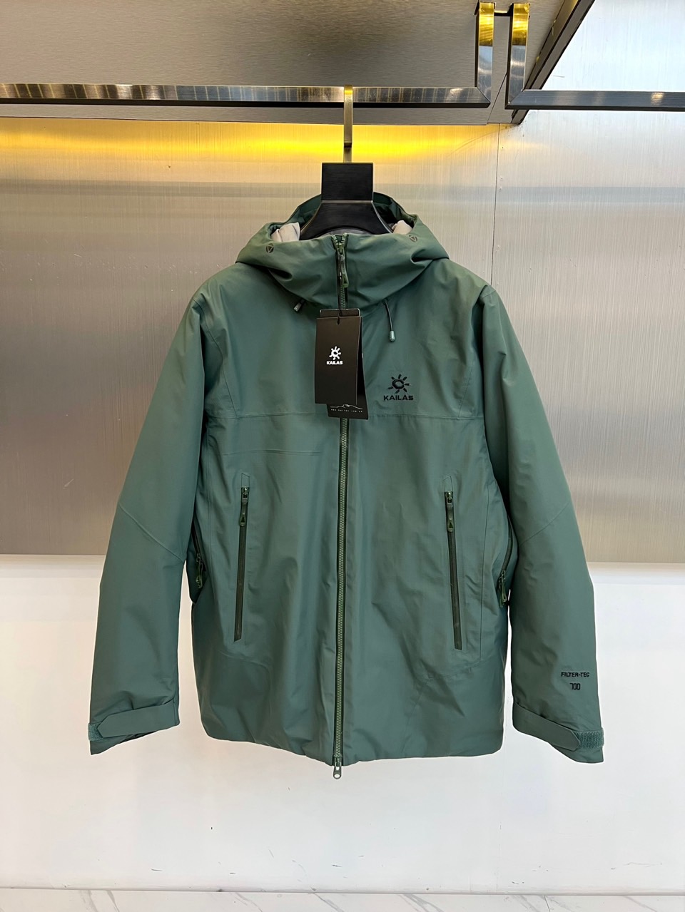 NO:648454,KAILAS (goose down), a new autumn and winter outdoor down jacket, features a hooded design and full zipper closure, creating a neat and practical outdoor silhouette. The left chest is decorated with the brand's 'KAILAS' wording and sun pattern logo to highlight its identity; the left sleeve is eye-catchingly printed with the 'FILTER-TEC 700' technical logo, implying that it is equipped with the brand's exclusive high-performance fabric technology. Zippered hand pockets are equipped on both sides for safe storage and simple styling.  This product strictly follows the standards of professional outdoor equipment. According to the washing label information, its main fabric and lining are made of nylon, which is light and wear-resistant. The filling is high-quality white goose down, with a velvet content of up to 90%, ensuring excellent thermal insulation efficiency in severe cold environments.  Its style perfectly combines hard-core functionality with urban fashion. The military green tone is calm and versatile, and the simple design lines make it not only suitable for outdoor scenes such as hiking and camping, but also can be easily integrated into daily commuting and urban life, creating a calm and professional outdoor functional style.  Through carefully selected velvet materials, solid craftsmanship and a humanized sizing system, Fan.Kaile Stone has created this cost-effective choice that combines reliable protection with modern aesthetics. S-XXL (model weighs 173,143 pounds, upper body size M),,jackets  & coats,down jacket,hats,alexander wang19860909KAILAS凯乐石（鹅绒）、秋冬新品户外羽绒服夹克,款式采用连帽设计与全拉链开合,打造利落实用的户外轮廓.左胸处饰有品牌“KAILAS”字样及太阳图案徽标,彰显身份；左袖醒目印有“FILTER-TEC 700”技术标识,暗示其搭载了品牌专属的高性能面料科技.两侧配备带拉链的插手口袋,兼顾安全收纳与简洁造型. 本品严格遵循专业户外装备标准.根据水洗标信息,其主布与里料均采用锦纶,轻盈耐磨.填充物为高品质白鹅绒,绒子含量高达90,确保在严寒环境中提供卓越的保暖效率. 其风格完美融合了硬核机能与都市时尚感.军绿色调沉稳百搭,简约的设计线条使其不仅能应对徒步、露营等户外场景,也能轻松融入日常通勤与城市生活,塑造出从容专业的户外机能风范.凯乐石通过严选的绒料、扎实的工艺与人性化的尺码体系,打造出这件兼具可靠防护性与现代审美的高性价比之选.S-XXL（模特173,143斤上身M码）,,jackets & coats,down jacket,hats,alexander wang,Men's clothing