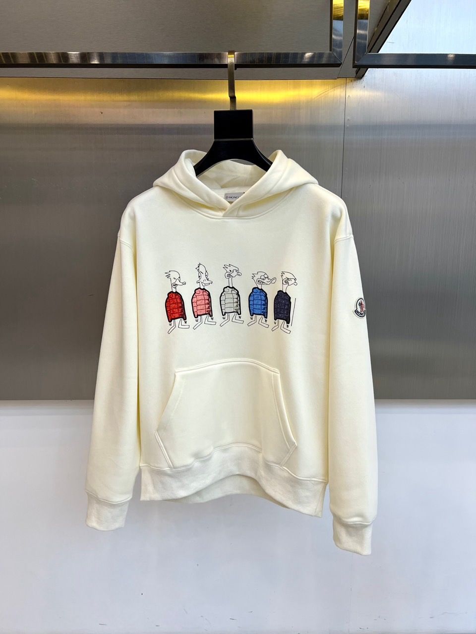 NO:648490,Moncler mask,  New autumn and winter velvet and thickened hooded sweatshirt, the style adopts a classic hooded design, combined with velvet and thickened air cotton material, bringing a fluffy and light wearing experience and excellent warmth retention. The front is decorated with a unique artistic print, depicting five agile animals wearing different colors of quilted clothing.  The anthropomorphic bird sewn into the down vest is colorful and full of fun. The left arm is embellished with the classic red round brand logo, and the cuffs and hem are trimmed with double threads to improve fit and windproof effect. The loose silhouette is paired with a three-dimensional kangaroo pocket to enhance the sense of practical functionality.  In terms of style, this sweatshirt cleverly combines Moncler's luxury sports genes and contemporary street fun. The vivid cartoon pattern injects artistic vitality and relaxed emotions, breaking the dullness of winter, while the exquisite craftsmanship and high-quality materials continue the consistent luxury texture. It is not only a topical and personalized item, it can be paired with simple bottoms alone, making the distinctive pattern the focus of the overall look; it is also an excellent layering piece  Wear it under the jacket and expose the hood and fun prints under the jacket, adding a touch of smartness to the modern layered look. This sweatshirt perfectly balances creative design, excellent functionality and daily practicality. It is a fashionable choice for the winter wardrobe that combines warmth, joy and high-end quality. M-4XL (model is 173,143 pounds, upper body size L), Moncler, hoodie, sweatshirts, jackets  & coats,down jacket,hats,alexander wang19860909Moncler蒙口、 秋冬新品加绒加厚连帽卫衣,款式采用经典连帽设计,结合加绒加厚的空气棉材质,带来蓬松轻盈的穿着体验与卓越保暖性.前襟饰以独特的艺术印花,描绘五只神态灵动、身着不同颜色绗缝羽绒马甲的拟人化飞鸟,色彩鲜活充满趣味.左臂点缀经典红色圆形品牌徽标,袖口与下摆采用双道螺纹收边工艺,提升贴合度与防风效果.宽松廓形搭配立体袋鼠兜,强化了实用机能感. 风格上,这款卫衣巧妙融合了Moncler的奢华运动基因与当代街头趣味.生动的卡通图案注入艺术活力与轻松情绪,打破了冬日的沉闷感,而精湛工艺与高品质材质则延续了一贯的奢潮质感.它既是一件充满话题性的个性单品,可单独搭配简约下装,以鲜明图案成为整体造型焦点；同时也是一件出色的叠穿内搭,在外套下露出连帽与趣味印花,为摩登层次穿搭增添灵动一笔.这件卫衣完美平衡了创意设计、卓越机能与日常实穿性,是冬日衣橱中兼具温暖、欢乐与高端品质的时髦选择.M-4XL（模特173,143斤上身L码）,,Moncler,hoodie,sweatshirts,jackets & coats,down jacket,hats,alexander wang,Men's clothing