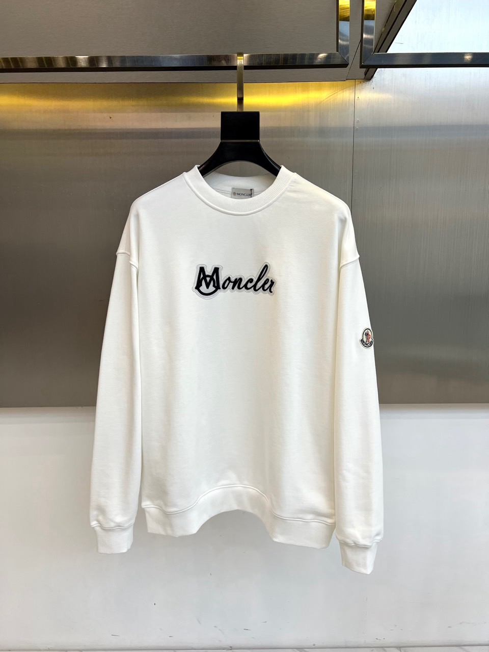 NO:648496,Mon's new autumn and winter sweatshirts adopt a classic round neck silhouette and are cut loosely and smoothly to ensure freedom and comfort when worn. The front is decorated with an eye-catching black 'Moncler' brand logo, with neat and modern fonts, forming a visual focus. On the left sleeve  It is embellished with brand logo patches of the same color, highlighting exquisite craftsmanship and brand identity with exquisite details. In terms of style, this sweatshirt perfectly inherits the genes of Meng Mou, which combines high-end sports and urban fashion. The pure white tone gives it a strong matchability, and can be worn as an inner layer on a heavy outer layer.  It reveals a touch of freshness in the set, or can be worn alone to show a simple style. Its design abandons complexity and highlights the quality with low-key logos and details. Whether it is used to create an all-white casual look, or mixed and matched with various types of bottoms, it can easily enhance the sophistication and style of the overall outfit.  It is a must-have item for your autumn and winter wardrobe that combines practicality, comfort and timeless style. 48-56 (model weighs 173,143 pounds, upper body size 50), Moncler, hoodie, sweatshirts, jackets  & coats,alexander wang19860909Mon蒙口、秋冬新品卫衣,款式采用经典圆领廓形,剪裁宽松流畅,确保穿着时的自在舒适度.正面饰有醒目的黑色“Moncler”品牌标识,字体利落现代,构成视觉焦点.左袖上点缀同色品牌标志贴布,以精致细节彰显精湛工艺与品牌身份.风格上,这款卫衣完美承袭了蒙口融合高端运动与都市时尚的基因.纯净的白色调赋予其极强的搭配性,既能作为内搭在厚重外套中露出一抹清爽,亦可单穿展现简约型格.其设计摒弃繁复,以低调的标识与细节凸显品质,无论是用于打造全白休闲造型,还是与各类下装混搭,都能轻松提升整体着装的精致与格调,成为秋冬衣橱中兼具实用性、舒适感与永恒风尚的必备单品.48-56（模特173,143斤上身50码）,,Moncler,hoodie,sweatshirts,jackets & coats,alexander wang,Men's clothing