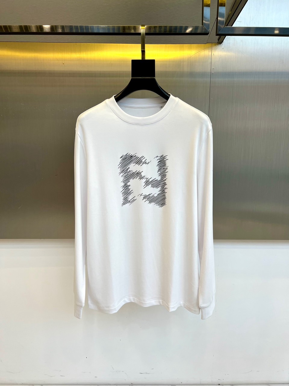 NO:650785,Fend Fendi, Fendi's 2025 new autumn and winter men's modal super-soft fabric long-sleeved T-shirt, interprets simple and luxurious daily aesthetics. This T-shirt is made of 47 modal, 47 cotton and 6 spandex fabrics in the golden ratio, which not only retains the skin-friendly breathability of cotton, but also is breathable.  The modal component gives it a velvety soft drape, while spandex provides just the right amount of elasticity and flexibility. The iconic round neck design is paired with a slim fit, and the front of the body is decorated with the brand's iconic graffiti-style letter 'F' pattern, showing an eclectic fashion style with artistic touches.  Fashionable attitude. Exquisite stitching technology ensures a crisp and neat silhouette, and the ratio of sleeve length to clothing length has been carefully considered to optimize the body shape modification effect. The overall design integrates Fendi Italian aesthetics into daily basics, which can be worn alone with casual trousers to show a simple style, or as an inner layer.  Wear suits or jackets layered to create an autumn and winter look that combines comfort and luxury, perfectly interpreting the sophisticated dressing philosophy of modern urban men. 48-56 (model weighs 173,143 pounds, upper body size 50),,fendi,fendi,jackets  & coats,tees,t-shirt,business suit,gold,alexander wang19860909Fend芬迪、芬迪2025秋冬新品男士莫代尔超柔面料长袖T恤,演绎简约奢华的日常美学.这款T恤采用47莫代尔、47棉与6氨纶的黄金比例面料,既保留了棉质的亲肤透气性,又通过莫代尔成分赋予丝绒般柔软垂坠感,氨纶则提供恰到好处的弹性灵活度.标志性的圆领设计搭配修身剪裁,衣身正面饰以品牌标志性的涂鸦风格字母'F'图案,以艺术化笔触展现不拘一格的时尚态度.精湛的缝线工艺确保版型挺括利落,袖长与衣长比例经过精心考量,优化身形修饰效果.整体设计将芬迪意式美学融入日常基础款,既可单独搭配休闲裤装展现简约风尚,也可作为内搭与西装或夹克叠穿,打造兼具舒适度与高级感的秋冬造型,完美诠释现代都市男士的精致着装哲学.48-56（模特173,143斤上身50码）,,fendi,fendi,jackets & coats,tees，t-shirt,business suit,gold,alexander wang,Men's clothing