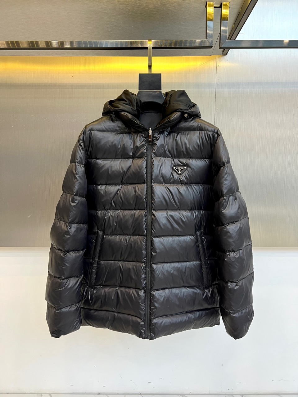 NO:650754,Prad, 2025 autumn and winter, new design launches this double-sided down jacket that is both smart and stylish. This product is made of high-tech matte fabric, presenting a simple and streamlined black outline. The iconic horizontal seams create a full three-dimensional sense and ensure excellent thermal insulation performance. The essence lies in the innovative double-sided wearable design with one side for fabric.  The classic hooded style is embellished with the brand's iconic triangular metal logo on the left chest, highlighting a low-key identity; the other side may show a completely different simple design or texture, which can be worn multiple times, doubling the fun and practicality of matching. The smooth metal front zipper, side hand pockets and adjustable windproof details all reflect the meticulous consideration of functionality.  The overall style perfectly combines Italian luxury genes with modern urban functionality. It can withstand the cold, and its neat tailoring and versatile attributes make it easy to adapt to various scenes from daily commuting to weekend leisure, making it a wise and stylish choice to cope with the autumn and winter climate. 48-56 (model 173,143 pounds, upper body size 50),, prada, prada, down jacket, hats, alexander wang19860909Prad普拉、2025秋冬,新款设计推出这款兼具智能与型格的双面穿羽绒服.本品采用高科技哑光面料,呈现简约流线的黑色轮廓,标志性的横向衍缝构筑饱满立体感,确保卓越保暖性能.其精髓在于创新的双面可穿设计一面为经典的连帽款式,左胸点缀品牌标志性三角形金属徽标,彰显低调身份；另一面则可能呈现截然不同的简约设计或质感,一衣多穿,倍增搭配趣味与实用性.顺滑的金属前拉链、侧边插手袋及可调节防风细节,均体现了对功能性的精细考量. 整体风格完美融合了意式奢华基因与现代都市机能感.它既能抵御严寒,其利落剪裁与多变属性更让它轻松适配从日常通勤到周末休闲的多种场景,成为应对秋冬气候的智慧与风格之选.48-56（模特173,143斤上身50码）,,prada,prada,down jacket,hats,alexander wang,Men's clothing