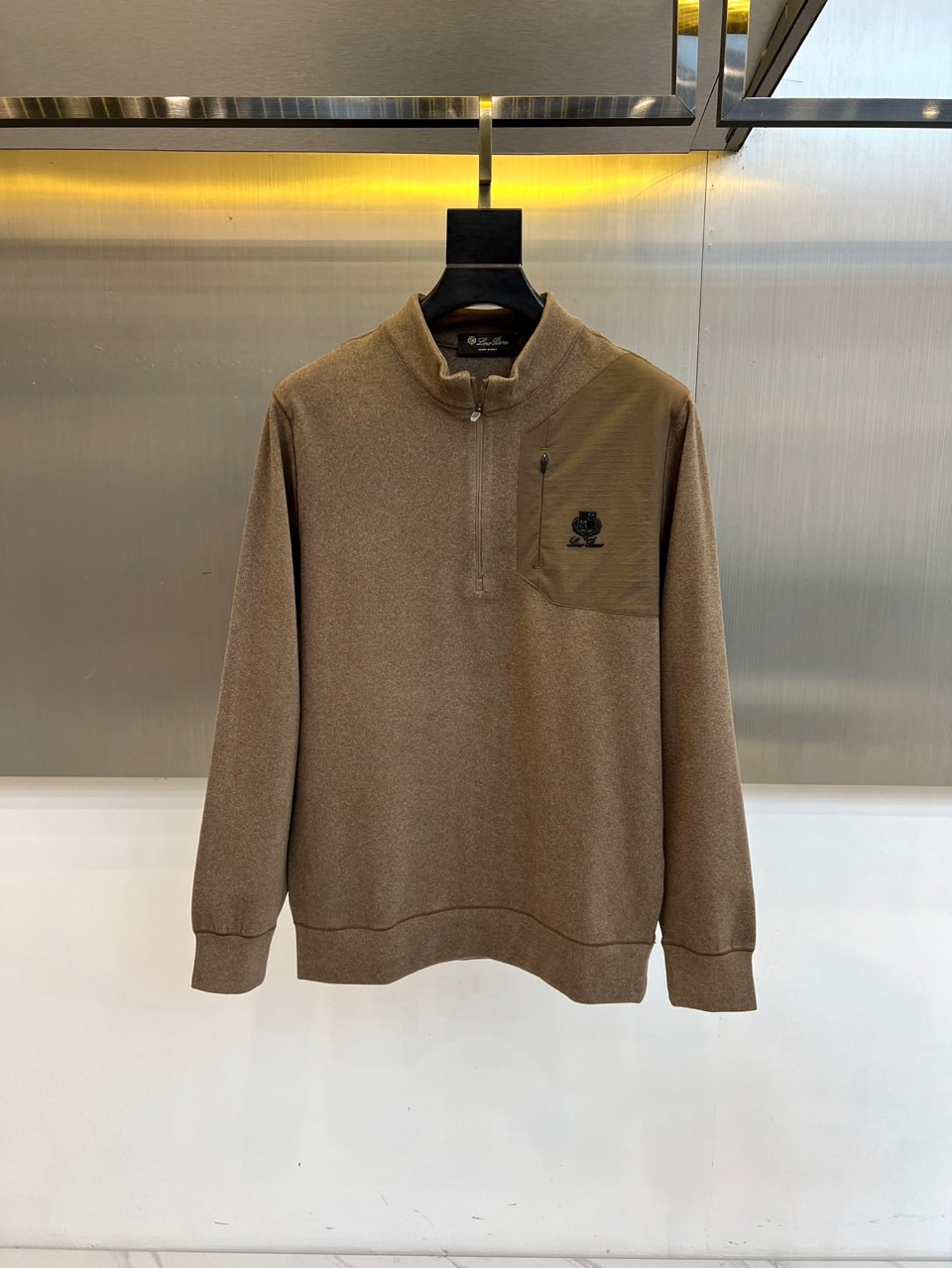 NO:650802,Loro Piana's 2025 autumn and winter new half-zip stand-up collar top uses classic gray to interpret low-key and simple Italian luxury aesthetics. This style adopts a half-high collar design, with a textured metal zipper, and the left chest is embellished with olive green splicing fabric, with an exquisite black brand logo embroidered on it, becoming the overall visual highlight. The slim and neat tailoring, combined with the delicate closing technology of the cuffs and hem, ensures a crisp and decent fit.  The fabric uses a precise ratio of 90% polyester fiber and 10% spandex, which cleverly combines the excellent stiffness of polyester fiber with the four-way elasticity provided by spandex. While ensuring a smooth and neat silhouette, it also gives the body full freedom of movement. The olive green splicing details form a subtle contrast with the gray main body, revealing exquisite taste in a calm atmosphere.  Integrating the brand's pursuit of ultimate fabrics and exquisite craftsmanship into daily design, every detail becomes a low-key luxury statement. This top can be worn alone to show a simple and modern style, or as a mid-layer match, easily adapting to multiple occasions from business and leisure to daily socializing. M-4XL (model 173,143 pounds, upper body size L),,loro piana,alexander wang19860909Loro Piana 2025秋冬新品半拉链立领上衣,以经典灰色演绎低调简约的意式奢华美学.该款式采用半高领设计,搭配质感金属拉链,左胸点缀橄榄绿色拼接面料,其上绣有精致的黑色品牌标识,成为整体的视觉亮点.修身利落的剪裁,配合袖口与下摆的细腻收口工艺,确保了穿着的挺括与得体. 面料选用90聚酯纤维与10氨纶的精准配比,巧妙融合了聚酯纤维的优良挺括性与氨纶提供的四向弹性,在保证版型流畅利落的同时,亦赋予身体充分的活动自由度.橄榄绿拼接细节与灰色主体形成含蓄对比,在沉稳大气中透露出精致品位. 将品牌对极致面料与精湛工艺的追求融入日常设计,让每一处细节都成为低调的奢华宣言.这款上衣既能单独穿着展现简约现代风格,亦可作为中层搭配,轻松适配从商务休闲到日常社交的多重场合.M-4XL（模特173,143斤上身L码）,,loro piana,alexander wang,Men's clothing