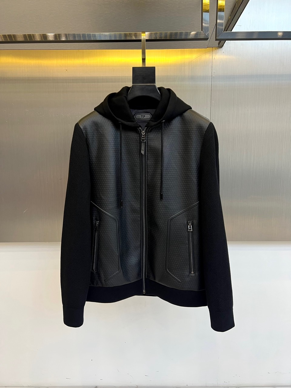 NO:650821,TF Tom Ford, 2025 autumn and winter new down jacket. Launched this PU leather spliced hooded down jacket that combines style and function. It takes urban functional aesthetics as its core and cleverly integrates different materials and processes.  The main body of the jacket is made of textured black PU leather fabric, giving it a distinct and modern silhouette. The essence lies in the splicing of knitted fabric on the sleeves and hem. The soft texture and the tough luster of the leather form a high-end contrast, which greatly enhances the layering and fashion of the design. The hood is equipped with a drawstring, practical zipper pockets on both sides, and an eye-catching silver front zipper, all emphasizing its casual functional attributes. The exquisite brand logo on the left chest is a low-key proof of quality.  The interior is filled with new national standard 90 high-quality white duck down to ensure sufficient warmth under a light body. The slim and neat tailoring makes it free from bloat. Whether it is paired with simple inner wear and trousers to create an all-black look, or mixed with casual clothes, it can easily interpret the cool sports style of the modern city. 48-56 (model 173,143 pounds, upper body size 50),, tom ford, jackets & coats, down jacket, hats, alexander wang19860909TF汤姆福特、2025秋冬新品羽绒外套.推出这款兼具型格与功能的PU皮拼接连帽羽绒茄克.它以都市机能美学为核心,巧妙融合不同材质与工艺. 外套主体采用质感黑色PU皮面料,赋予其鲜明而摩登的轮廓.精髓在于袖部与下摆的针织面料拼接,柔软的肌理与皮质的硬朗光泽形成高级对比,极大提升了设计的层次感与时尚度.连帽搭配抽绳,双侧实用的拉链口袋,以及醒目的银色前襟拉链,均强调了其休闲机能属性.左胸处的精致品牌标识,低调印证品质. 内部填充新国标90高品质白鸭绒,确保轻盈体感下的足够保暖性.修身利落的剪裁使其摆脱臃肿,无论是搭配简约内搭与长裤打造全黑造型,还是与休闲服饰混搭,都能轻松演绎现代都市的酷感运动风格.48-56（模特173,143斤上身50码）,,tom ford,jackets & coats,down jacket,hats,alexander wang,Men's clothing