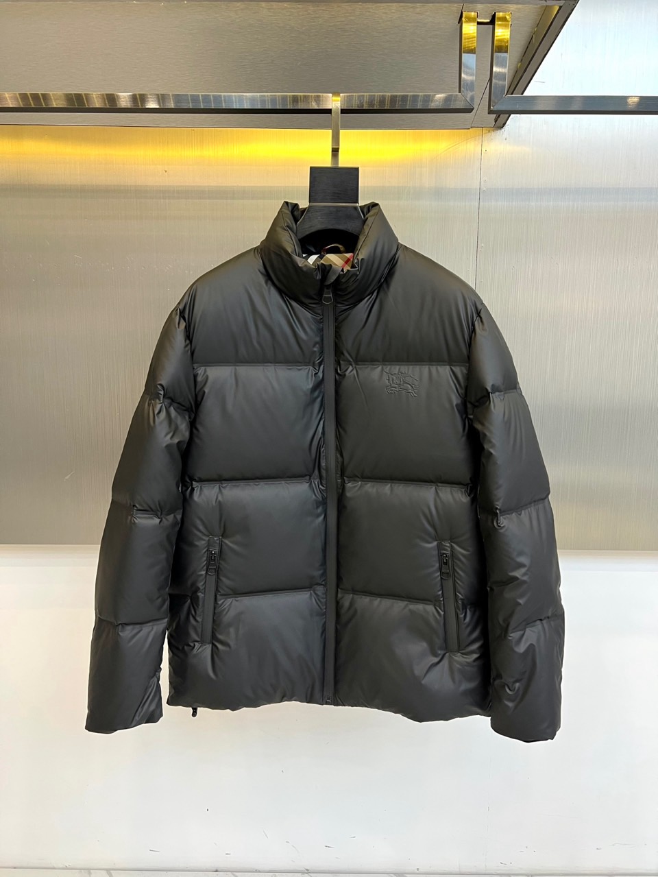 NO:656083,Burberry, the new 2025 autumn and winter down jacket, uses classic black to interpret the winter style of the modern city. The neat stand-up collar and simple zipper opening and closing outline a tall and smooth silhouette. The exquisite diamond-shaped plaid quilting on the body not only enriches the visual texture, but also ensures the even distribution of fillings, showing exquisite craftsmanship. The left chest is decorated with classic brand logo embroidery, low-key highlighting the brand identity. The diagonal pockets on both sides are integrated into the overall lines and have practical functions. This product is made of high-quality nylon fabric, which has both flexible texture and windproof performance. Its core is filled with high-quality white duck down, with a down content of up to 90%, which is light and fluffy and has excellent temperature locking performance, ensuring a long-lasting warm wearing experience in cold seasons. The overall design combines iconic British genes with modern minimalist aesthetics, with exquisite tailoring and exquisite details. Famous. Whether paired with formal wear to create a smart urban image, or combined with casual wear, it can be easily adapted to a variety of occasions, becoming a timeless choice for autumn and winter wardrobes that combines timeless style and practical function. 48-56 (model weighs 173,143 pounds, upper body size 50),, burberry, burberry, down jacket,alexander wang19860909Bur巴宝莉、2025秋冬新款羽绒服,以经典黑色演绎摩登都会的冬日风范.利落立领与简洁拉链开合,勾勒出挺拔流畅的轮廓.衣身精致的菱形格纹绗缝不仅丰富了视觉肌理,更确保了填充物的均匀分布,尽显精湛工艺.左胸饰有经典的品牌标识刺绣,低调彰显品牌身份.两侧的斜插口袋融入整体线条,兼具实用功能. 本品选用高品质锦纶面料,兼具柔韧质感与防风性能.其核心填充高品质白鸭绒,绒子含量高达90,轻盈蓬松,锁温性能卓越,确保在寒冷季节提供持久温暖的穿着体验.整体设计将标志性的英伦基因与现代极简美学相融合,以精湛剪裁和考究细节著称.无论是搭配正装打造干练的都市形象,还是与休闲服饰组合,都能从容适应多种场合,成为秋冬衣橱中兼具永恒风格与实用功能的隽永之选.48-56（模特173,143斤上身50码）,,burberry,burberry,down jacket,alexander wang,Men's clothing