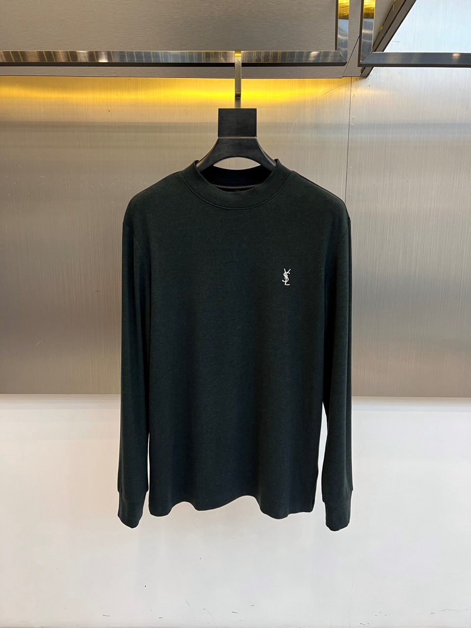 NO:656098,Saint Laurent, the 2025 autumn and winter long-sleeved T-shirt series, reshapes basic items with the iconic rock core. The series presents four timeless colors of pure black, dark grey, dark brown and dark green to meet the multi-level autumn and winter matching needs. Each item adopts a simple round neck cut and slim silhouette, with neat and smooth lines. The left chest is embellished with the classic white Saint Laurent logo embroidery, highlighting the uninhibited identity in a low-key manner.  This series uses 95% cotton and 5% spandex blended fabrics, taking into account the softness of cotton and the moderate elasticity brought by spandex, ensuring unrestricted comfort and excellent silhouette retention when wearing. The unique drape texture of the fabric further enhances the overall high-end look and feel. The overall design abandons complexity and accurately focuses on the shape, touch and iconic details.  Inject the soul of the brand into daily life. Whether worn alone with leather pants to interpret a rebellious style, or worn as an inner layer under a suit or coat to reveal the collar logo, you can easily create a sexy, cool and timeless Saint Laurent style, which is the luxurious cornerstone of this season's wardrobe. 48-56 (model is 173, 143 pounds, upper body size 50),, saint  laurent, saint laurent, tees, t-shirt, alexander wang19860909Saint Laurent圣罗兰、2025秋冬长袖T恤系列,以标志性的摇滚内核重塑基础单品.系列呈现纯黑、深灰、深棕与墨绿四款隽永色调,满足多层次的秋冬搭配需求.每件单品均采用简约的圆领剪裁与修身廓形,线条利落流畅.左胸口点缀经典的白色圣罗兰徽标刺绣,于低调中彰显不羁身份. 本系列选用95棉与5氨纶混纺面料,兼顾棉质的柔软亲肤与氨纶带来的适度弹性,确保穿着时拥有无拘的舒适感与出色的廓形保持力.其面料特有的垂坠质感,进一步提升了整体的高级观感.整体设计摒弃繁复,精准聚焦于版型、触感与标志性细节,将品牌灵魂注入日常.无论是单穿搭配皮裤诠释叛逆型格,或作为内搭在西服与大衣下露出领口标志,皆能轻松塑造出性感、冷峻而永不过时的圣罗兰风格,是构建本季衣橱的奢华基石.48-56（模特173,143斤上身50码）,,saint laurent,saint laurent,tees，t-shirt,alexander wang,Men's clothing