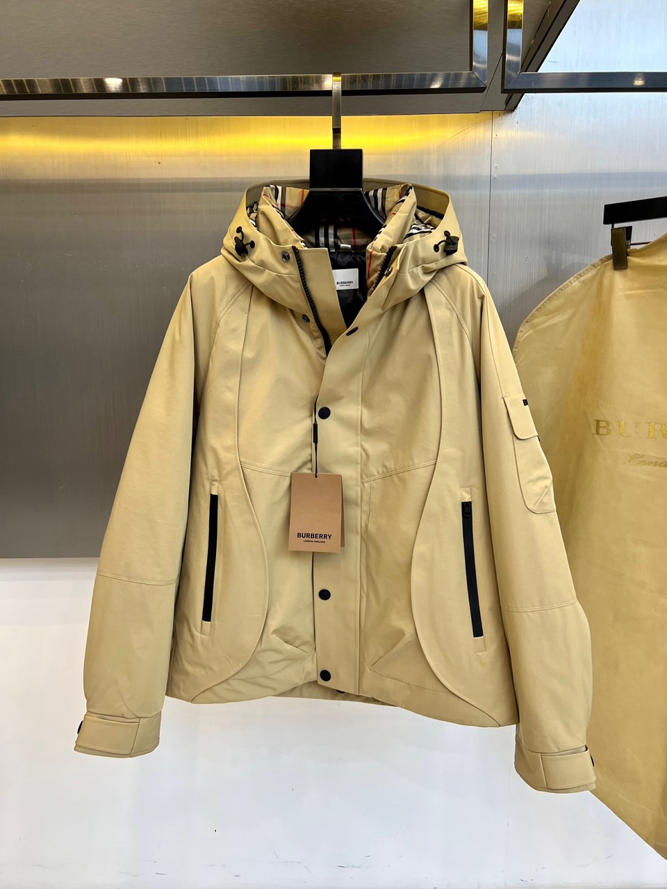 NO:656103,Burberry (high-end white goose down), 2025 autumn and winter new men's hooded down jacket, uses classic khaki color to interpret modern British style. The three-dimensional cut hood design is equipped with an adjustable drawstring, which has both windproof function and styling. The front is made of black  It has a double closure system of colored buttons and hidden zippers, and the left chest is embellished with the brand's iconic webbing label. The diagonal pockets on both sides and the hidden zipper pocket on the left sleeve form a multi-functional storage combination. The classic plaid lining is hidden on the inside of the collar, highlighting the heritage gene in every detail.  The filling is made of natural white goose down, with a cashmere content of 90%, and the origin of the fiber material is clearly marked in Taiwan. The fabric is full of technology, the main body is made of coated fabric, and the lining is polyester fiber. The hood lining and collar lining are specially made of a luxurious blend of 70 wool/20 nylon/10 cashmere, and the cuffs are made of an elastic combination of 85 cotton/14 nylon/1 spandex to ensure wearing comfort and freedom of movement.  This down jacket perfectly combines Burberry's century-old craftsmanship with contemporary functional needs. The three-dimensional tailoring takes into account both warmth and slimming effect. It can not only withstand severe cold weather, but also match with formal wear or casual items to present a variety of styles. From the quality of goose down to the material ratio of details, every detail  They all reflect the brand's insistence on excellent quality and are investment-grade items that are both practical and fashionable in the winter wardrobe. 48-56 (model weighs 173,143 pounds, upper body size 50),, burberry, burberry, jackets  & coats,down jacket,hats,alexander wang19860909Bur巴宝莉（高端白鹅绒）、2025秋冬新品男士连帽羽绒外套,以经典卡其色演绎现代英伦风尚.立体剪裁的连帽设计配备可调节抽绳,兼具防风功能与造型感.前襟采用黑色纽扣与隐藏式拉链双重闭合系统,左胸点缀品牌标志性织带标签.两侧斜插口袋与左袖隐藏式拉链袋形成多功能收纳组合,领口内侧暗藏经典格纹衬里,于细节处彰显传承基因. 填充物选用天然白鹅羽绒,含绒量达90高品质标准,并明确标注纤维物料原产地台湾.面料科技感十足,主体采用涂层面料,内衬为聚酯纤维,帽内衬与领口内衬特别采用70羊毛/20尼龙/10羊绒的奢华混纺材质,袖口则使用85棉/14尼龙/1氨纶的弹性组合,确保穿着舒适度与活动自由度. 这款羽绒服将巴宝莉的百年工艺与当代机能需求完美结合,立体剪裁兼顾保暖性与修身效果,既能抵御严寒气候,又能搭配正装或休闲单品呈现多样风格.从鹅绒品质到细节材质配比,每一处都体现着品牌对卓越品质的坚持,是冬日衣橱中兼具实用与时尚的投资级单品.48-56（模特173,143斤上身50码）,,burberry,burberry,jackets & coats,down jacket,hats,alexander wang,Men's clothing