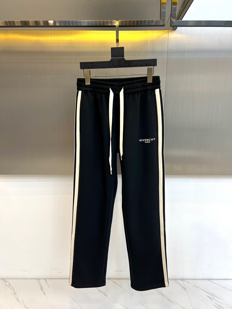 Given纪梵希、2025秋冬新品男士休闲裤，侧边装饰经典黑色条纹，从裤腰延伸至裤脚，形成流畅的视觉线条