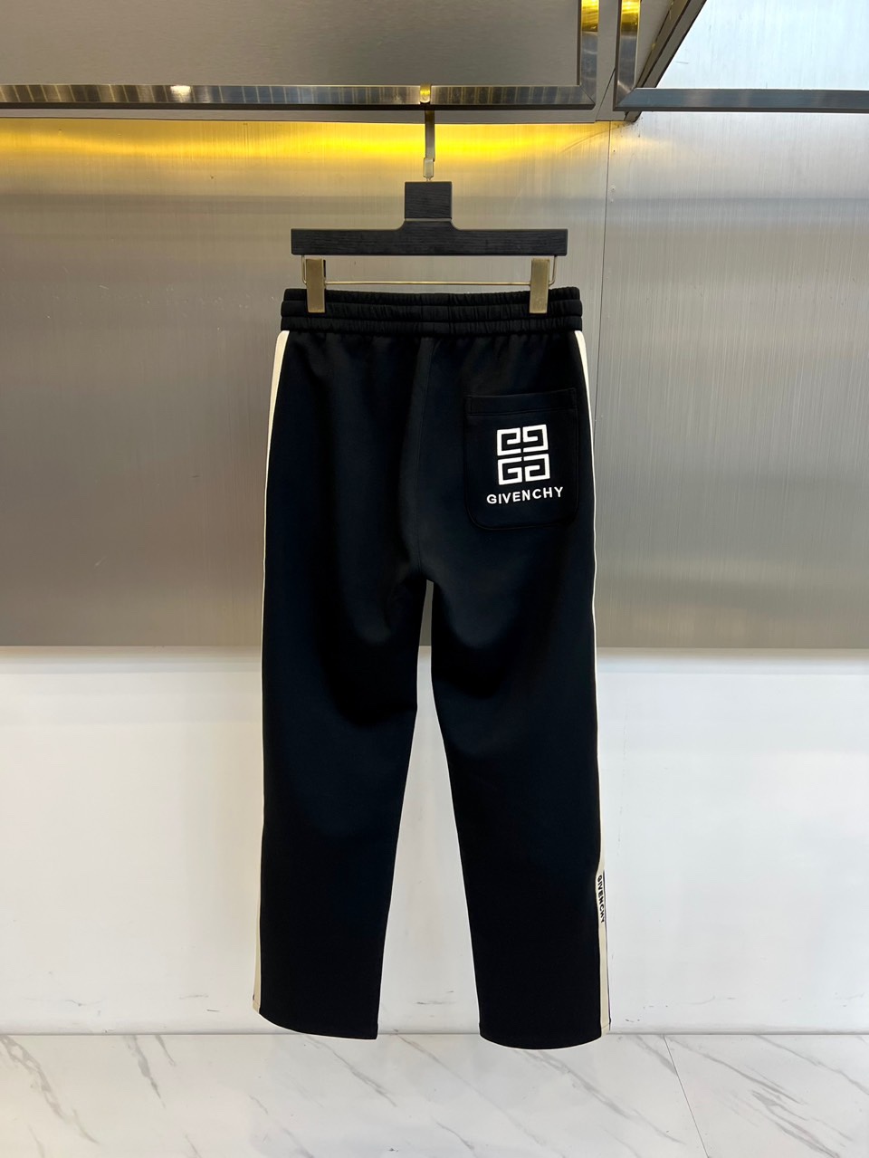 Given纪梵希、2025秋冬新品男士休闲裤，侧边装饰经典黑色条纹，从裤腰延伸至裤脚，形成流畅的视觉线条