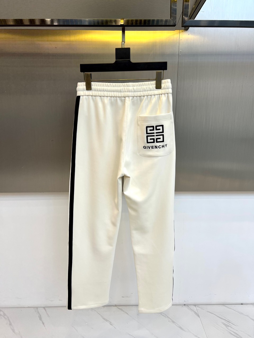 Given纪梵希、2025秋冬新品男士休闲裤，侧边装饰经典黑色条纹，从裤腰延伸至裤脚，形成流畅的视觉线条