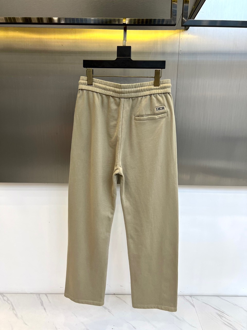 Dio迪奥、2025秋冬新品卡其色休闲裤，以宽松直筒廓形演绎现代休闲美学。腰部采用松紧腰头与抽绳双重设计