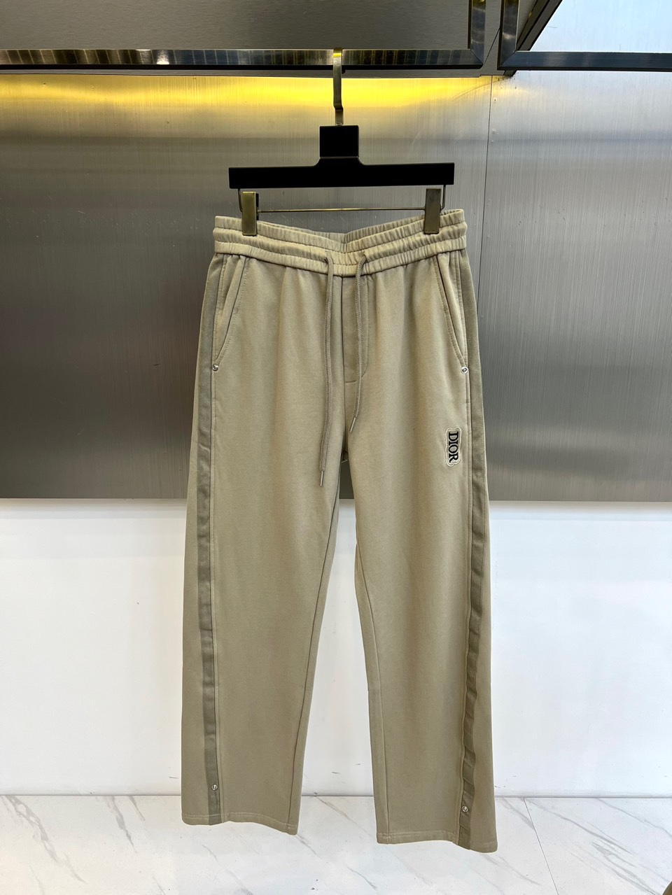 Dio迪奥、2025秋冬新品卡其色休闲裤，以宽松直筒廓形演绎现代休闲美学。腰部采用松紧腰头与抽绳双重设计