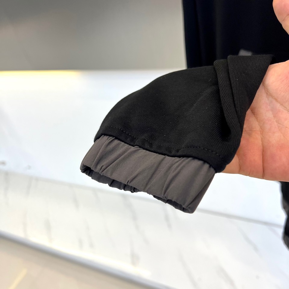 Prad普拉、2025秋冬新作连帽卫衣，款式采用连帽设计搭配可调节抽绳，胸前饰有品牌标志性三角徽标，下方