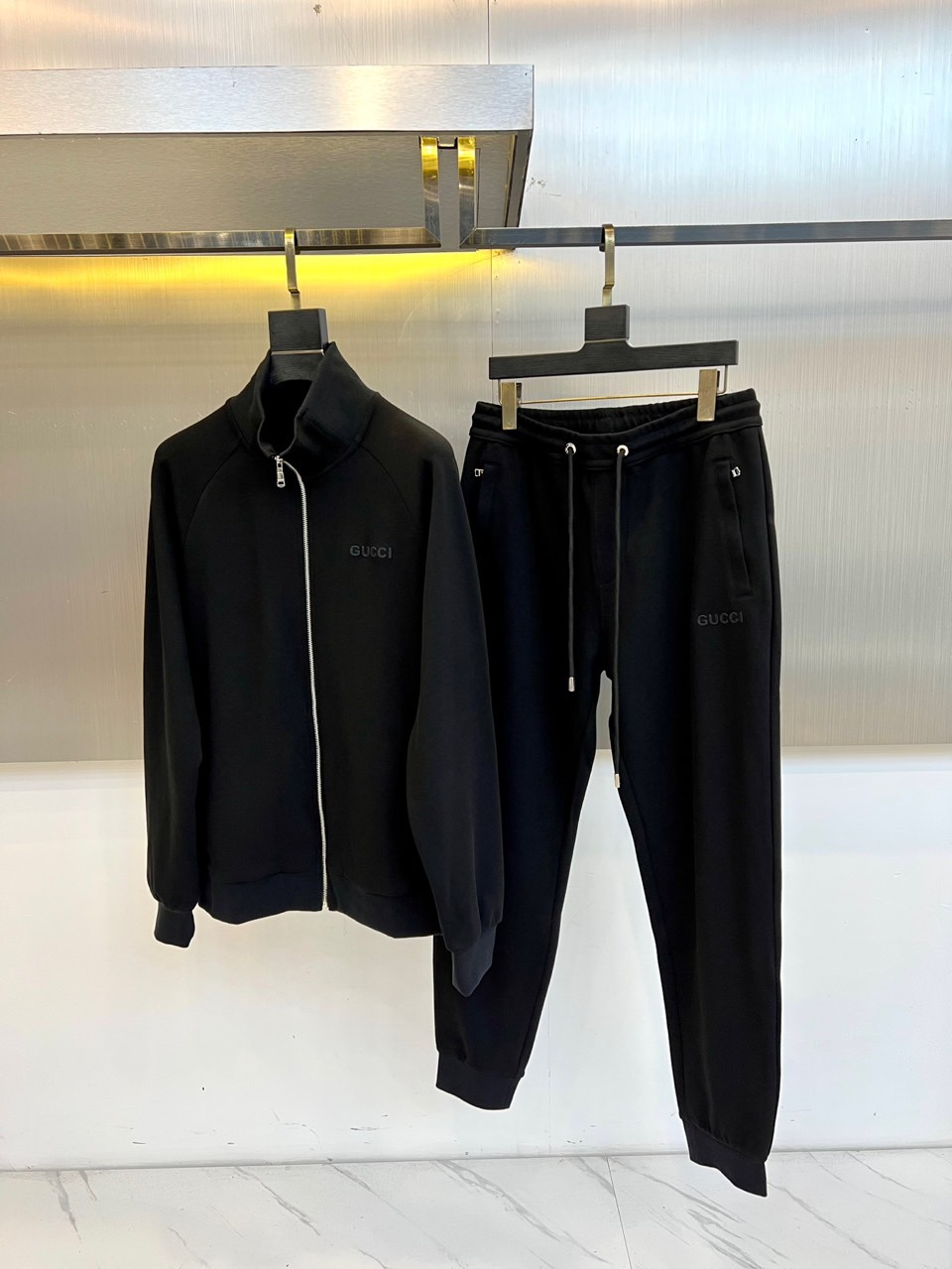 Gucc古驰、2025秋冬新品 GU暖棕休闲套装。这款暖棕色套装由立领拉链外套与抽绳束脚裤组成整体造型。