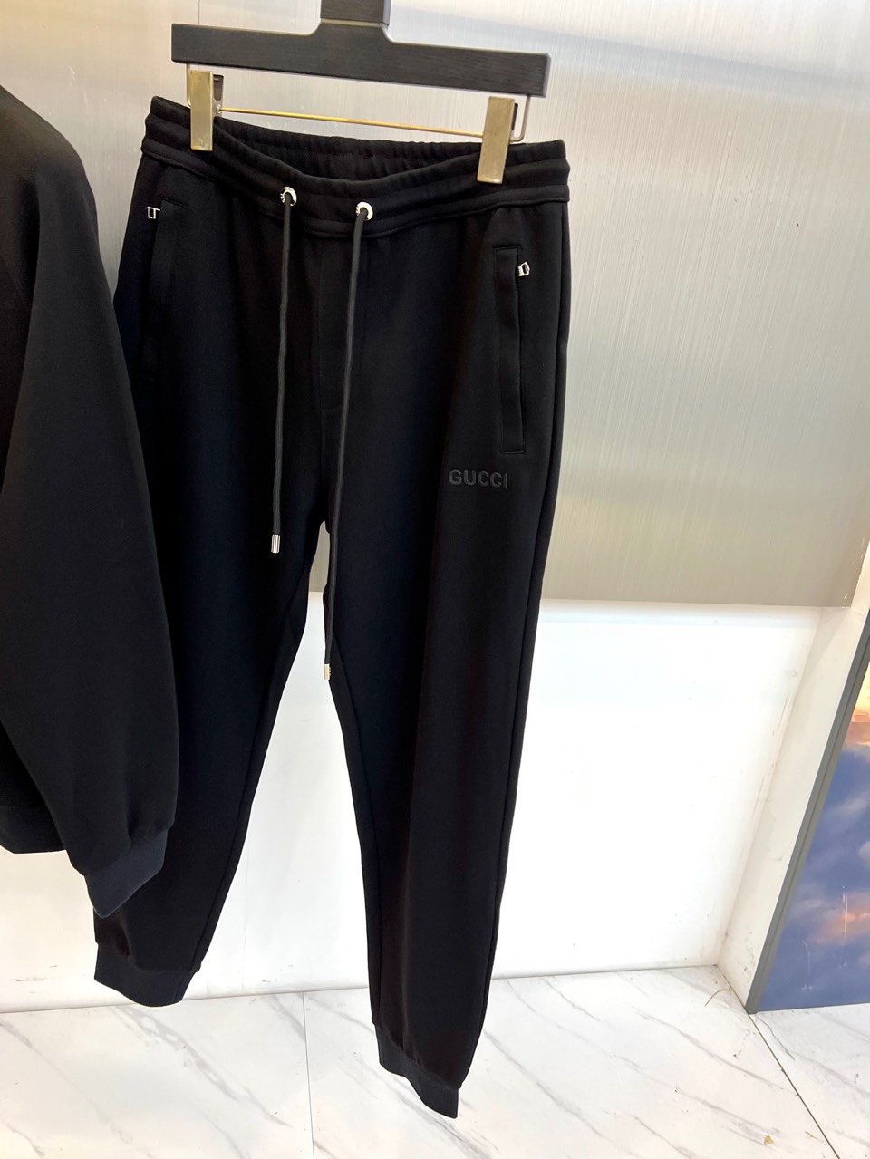 Gucc古驰、2025秋冬新品 GU暖棕休闲套装。这款暖棕色套装由立领拉链外套与抽绳束脚裤组成整体造型。