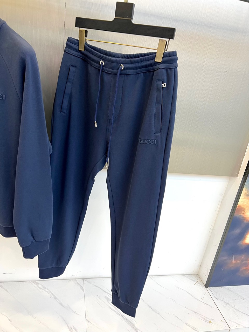 Gucc古驰、2025秋冬新品 GU暖棕休闲套装。这款暖棕色套装由立领拉链外套与抽绳束脚裤组成整体造型。