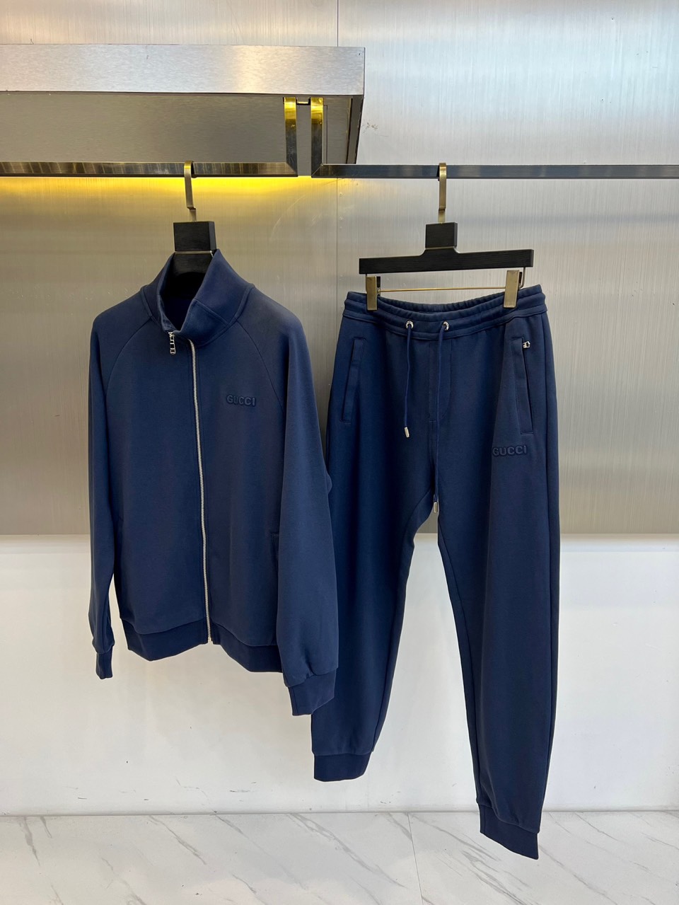 Gucc古驰、2025秋冬新品 GU暖棕休闲套装。这款暖棕色套装由立领拉链外套与抽绳束脚裤组成整体造型。