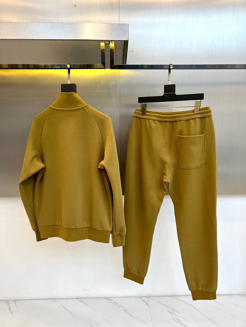 Gucc古驰、2025秋冬新品 GU暖棕休闲套装。这款暖棕色套装由立领拉链外套与抽绳束脚裤组成整体造型。