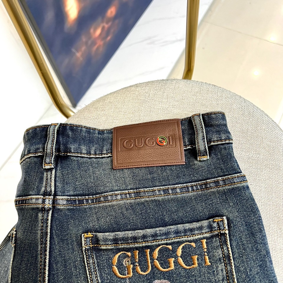 Gucc古驰、2025秋冬新品 GUCCI刺绣徽章牛仔裤，这款深蓝色牛仔裤采用品牌标志性设计，后袋处以金