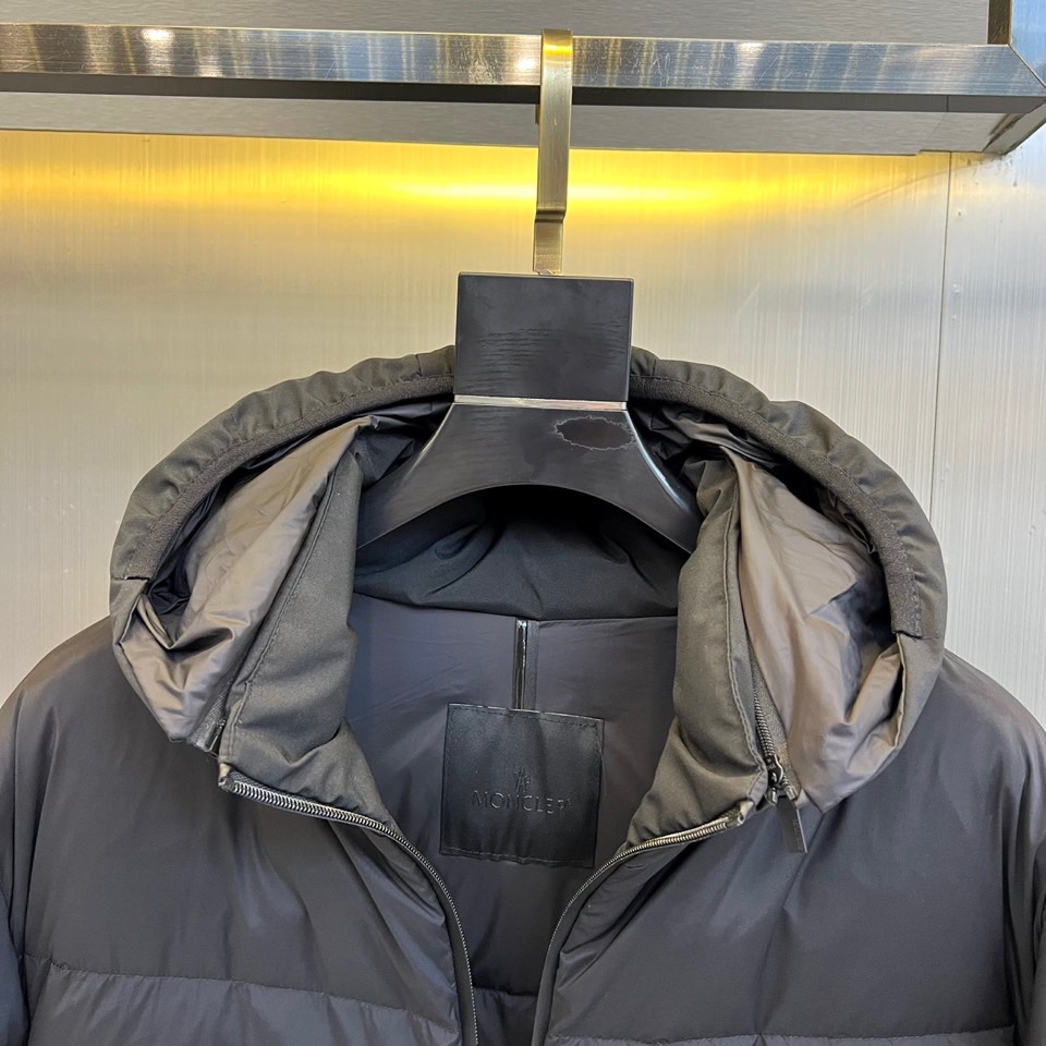 蒙口、2025秋冬新品羽绒服，这款连帽羽绒服采用规整的方块绗缝工艺，勾勒出立体饱满的轮廓线条。黑色拉链自