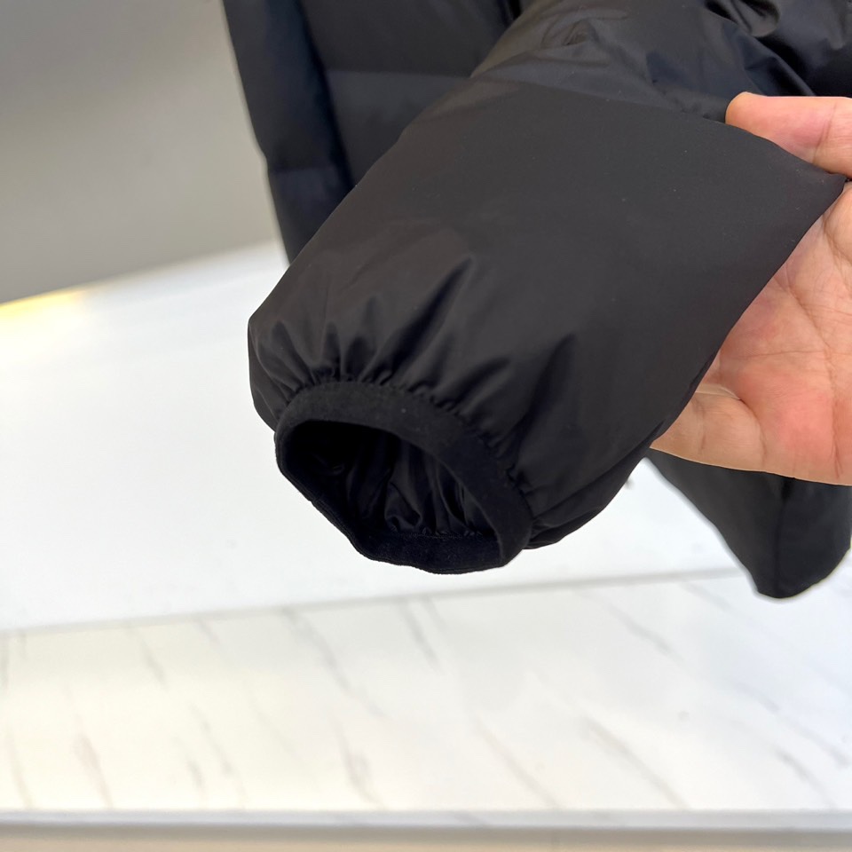 蒙口、2025秋冬新品羽绒服，这款连帽羽绒服采用规整的方块绗缝工艺，勾勒出立体饱满的轮廓线条。黑色拉链自