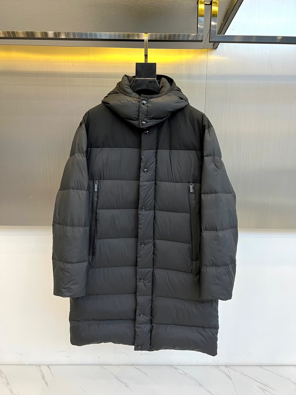 Mon蒙口（纯鹅绒）、2025秋冬新品长款羽绒服，以经典黑色演绎冬日奢华防护美学。这款羽绒服采用100%