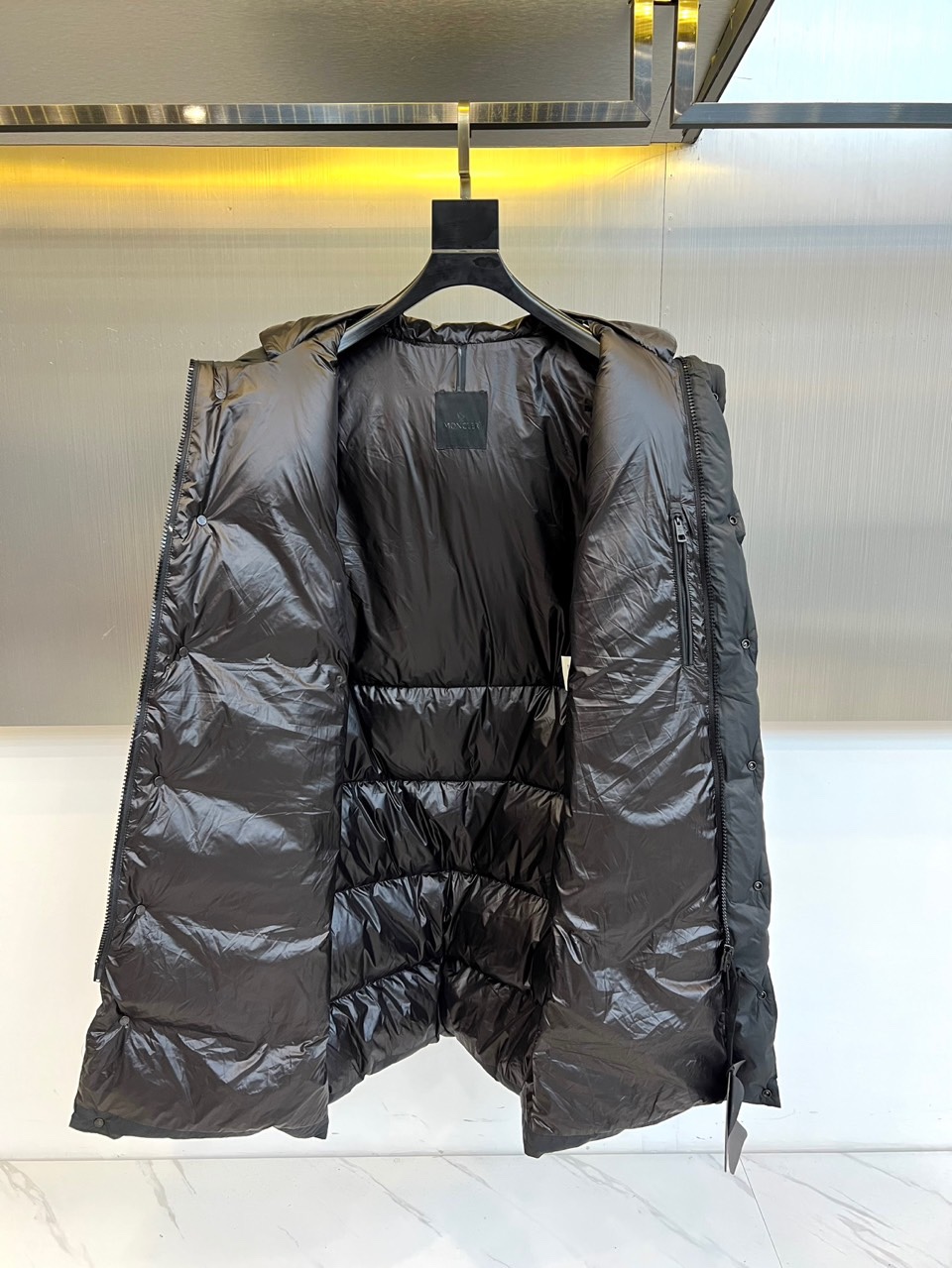 Mon蒙口（纯鹅绒）、2025秋冬新品长款羽绒服，以经典黑色演绎冬日奢华防护美学。这款羽绒服采用100%