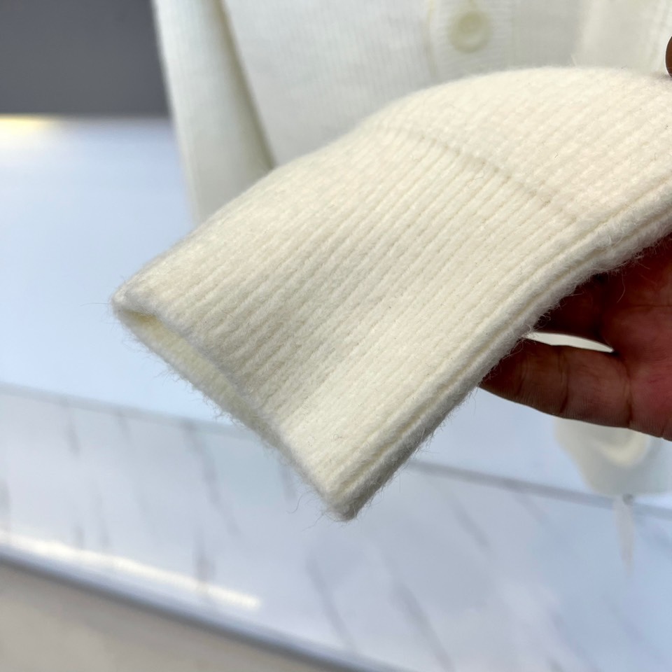 Ch克罗心，2025秋冬新品白色针织开衫，款式采用经典V领设计，搭配四颗黑色圆形树脂纽扣，可随性调节开合