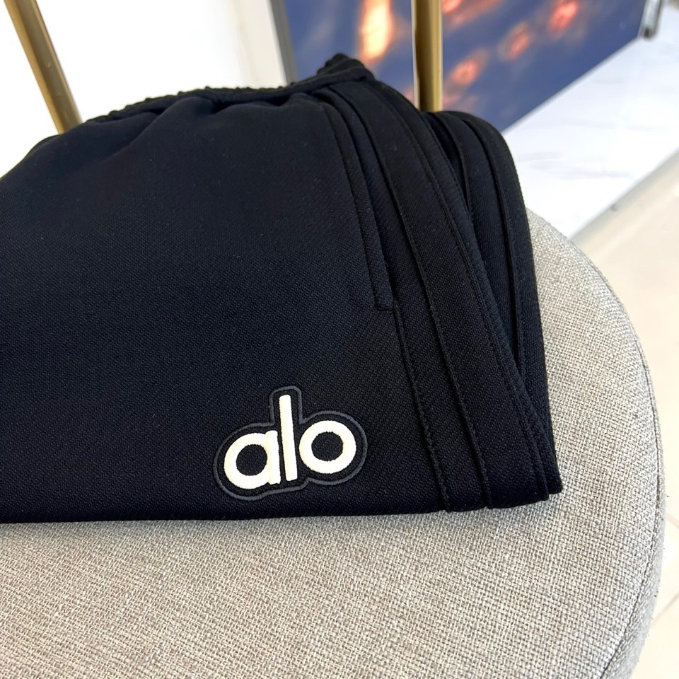 Alo-2025秋冬新品运动裤，款式采用直筒廓形搭配弹性抽绳腰头，裤身两侧饰有线条装饰延伸至裤脚，左腿处
