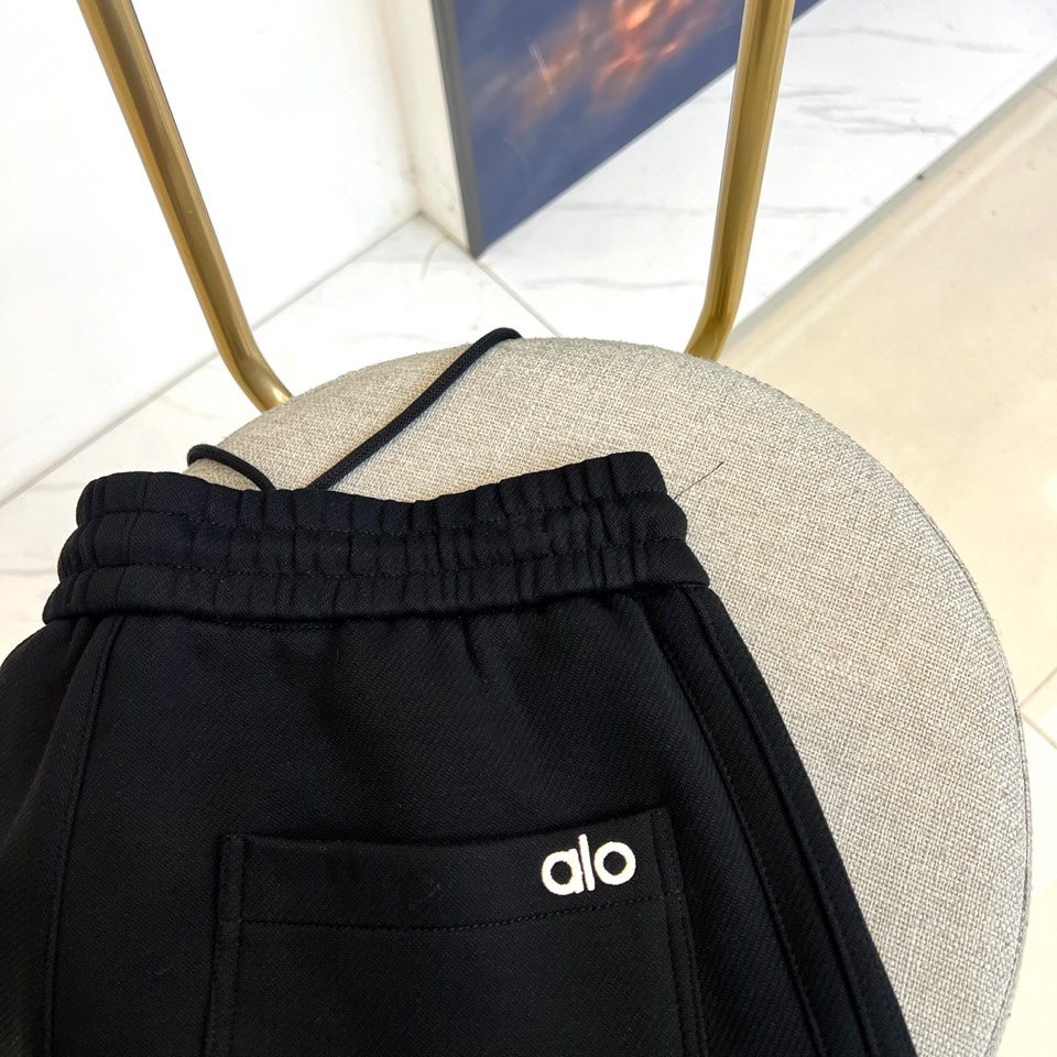 Alo-2025秋冬新品运动裤，款式采用直筒廓形搭配弹性抽绳腰头，裤身两侧饰有线条装饰延伸至裤脚，左腿处